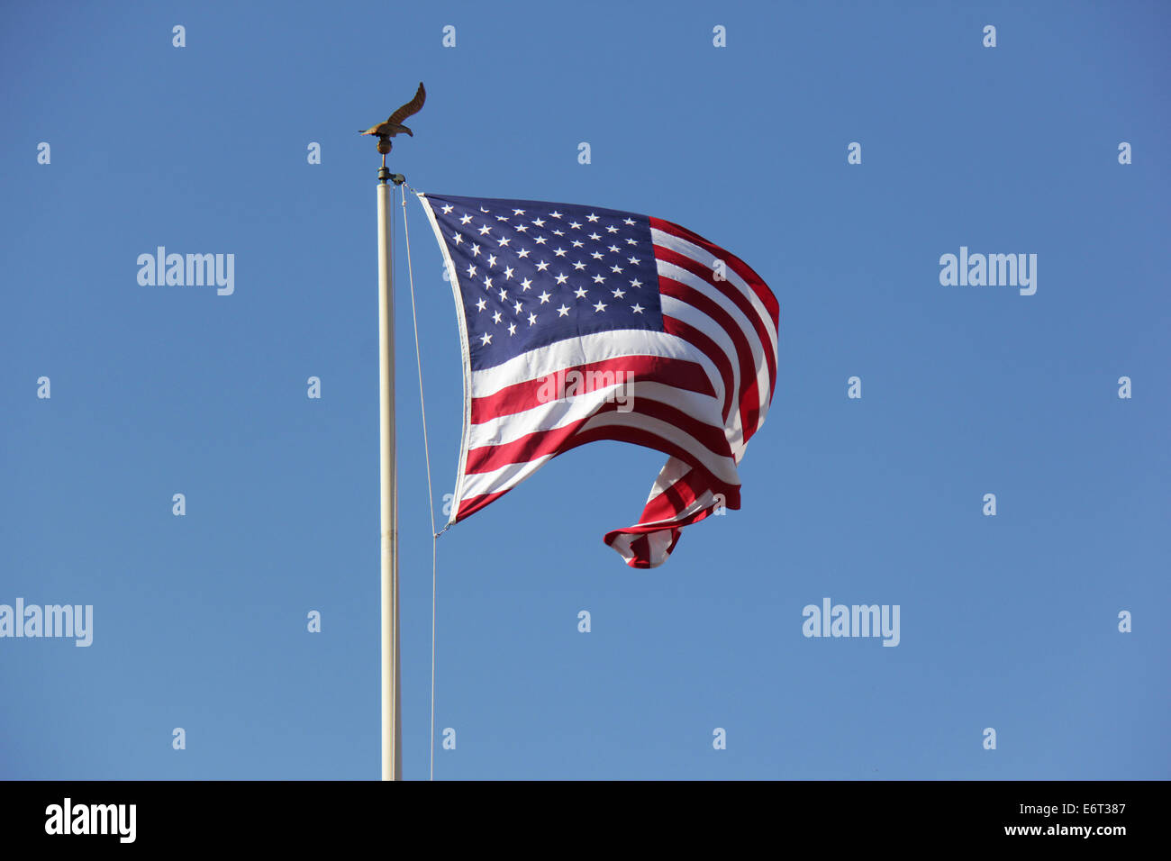 American flag flying on a blue sky Stock Photo - Alamy