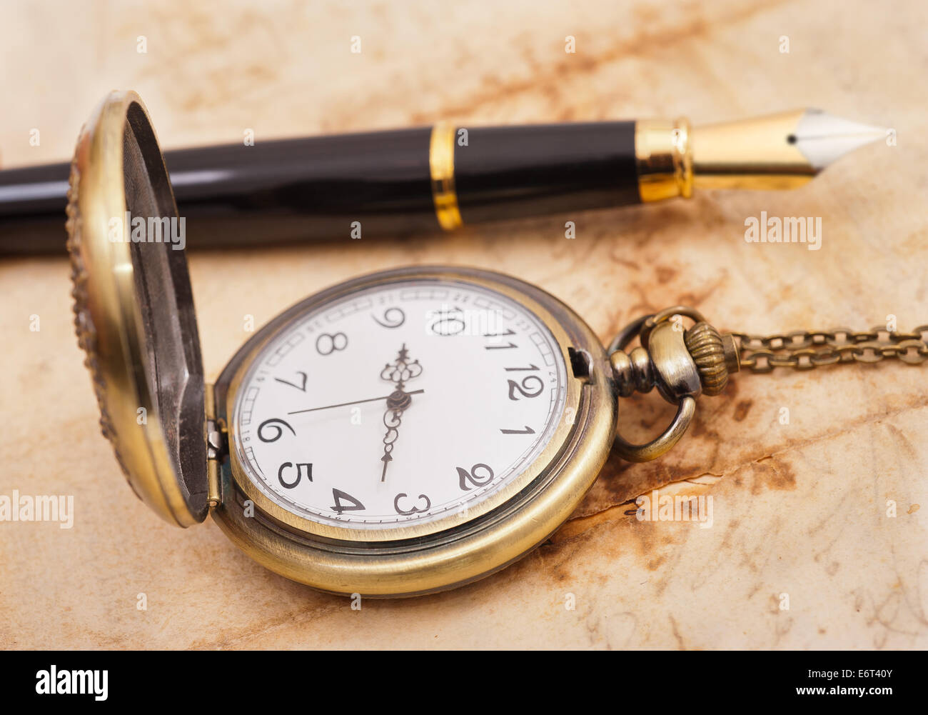 fountain pen and pocketwatch on old sheet Stock Photo