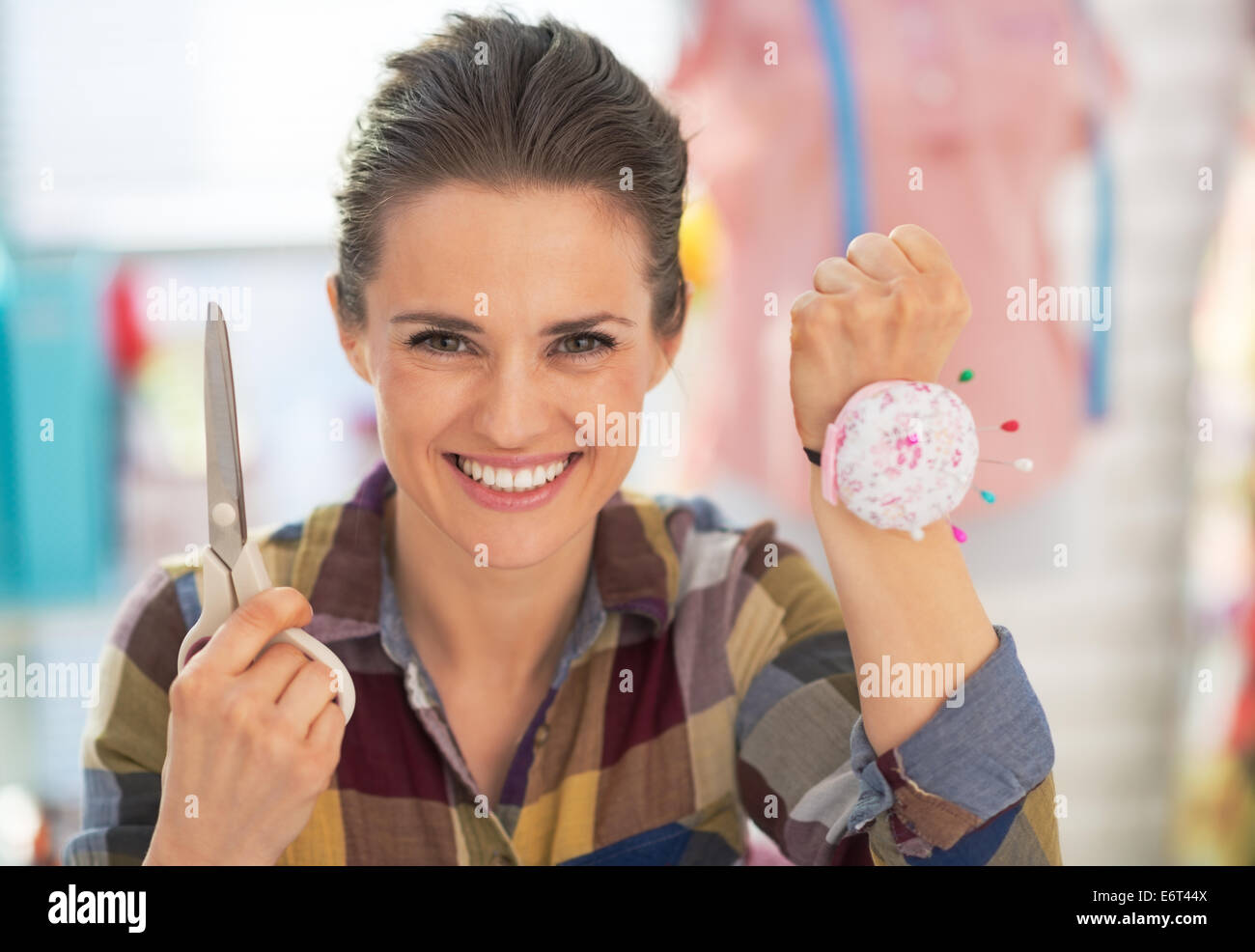 Portrait of dressmaker woman showing scissors and pincushion Stock Photo