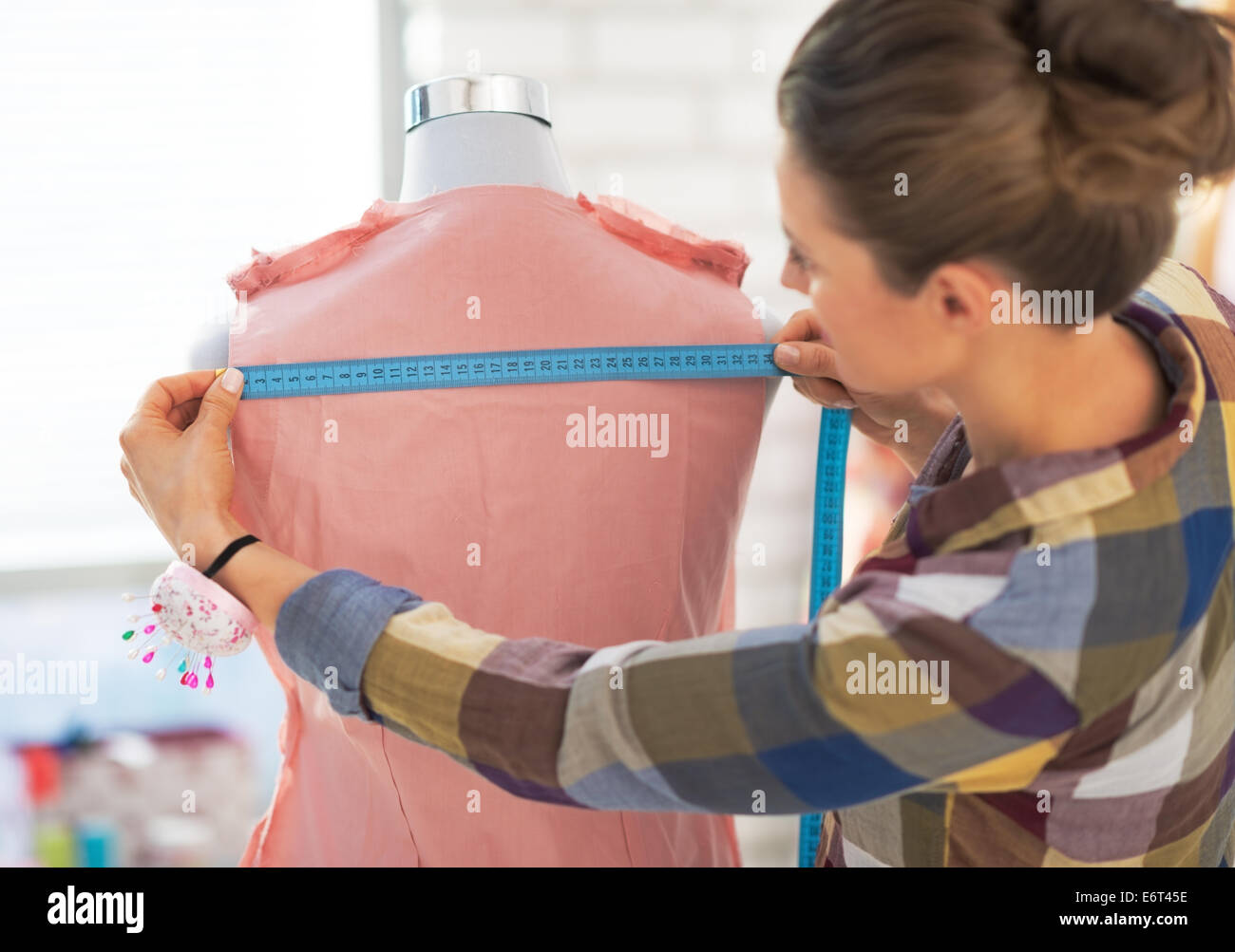 Tailor woman working with dress in studio Stock Photo - Alamy