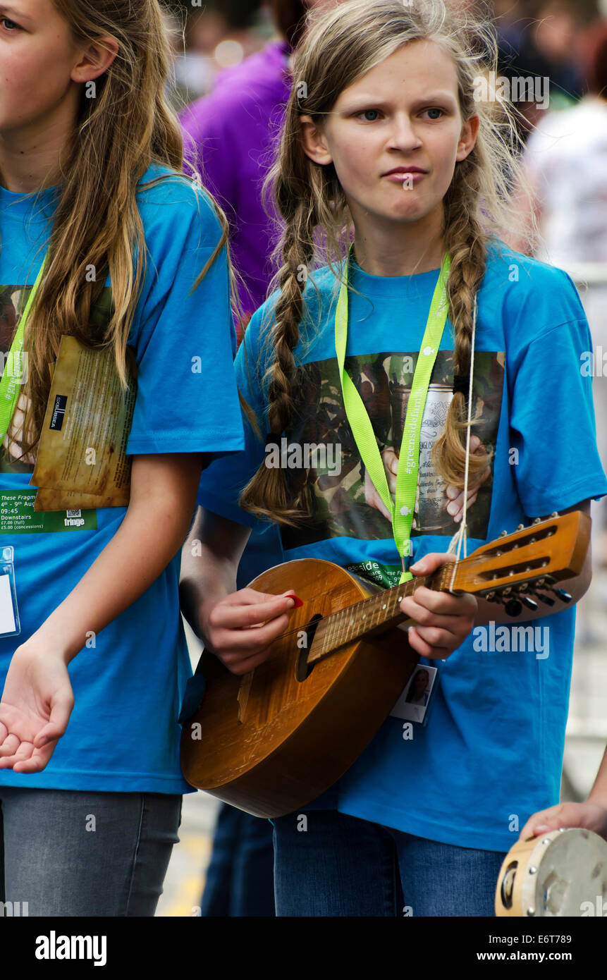 Young girl playing mandolin with a school singing group promoting a show at the annual Festival Fringe in Edinburgh, Scotland. Stock Photo