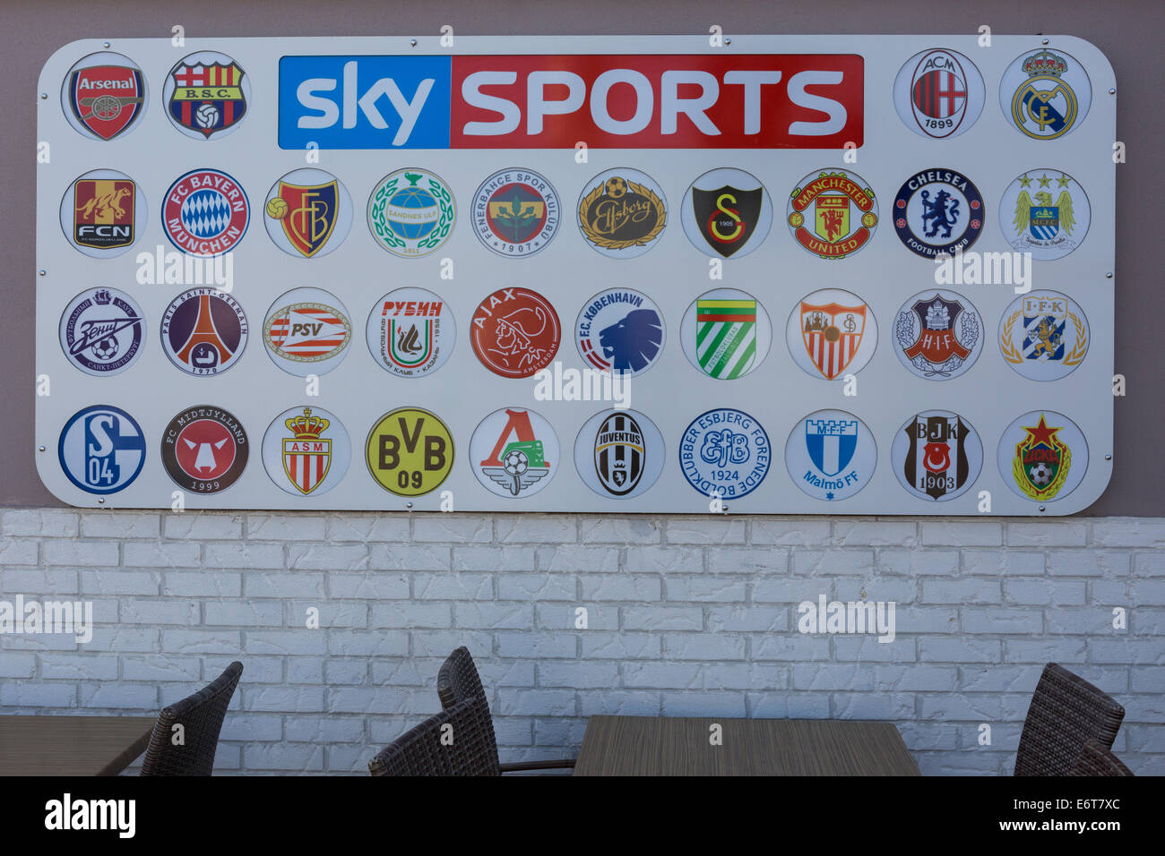 A board outside a bar displays the emblems of Champions League football teams under the Sky Sports logo Stock Photo