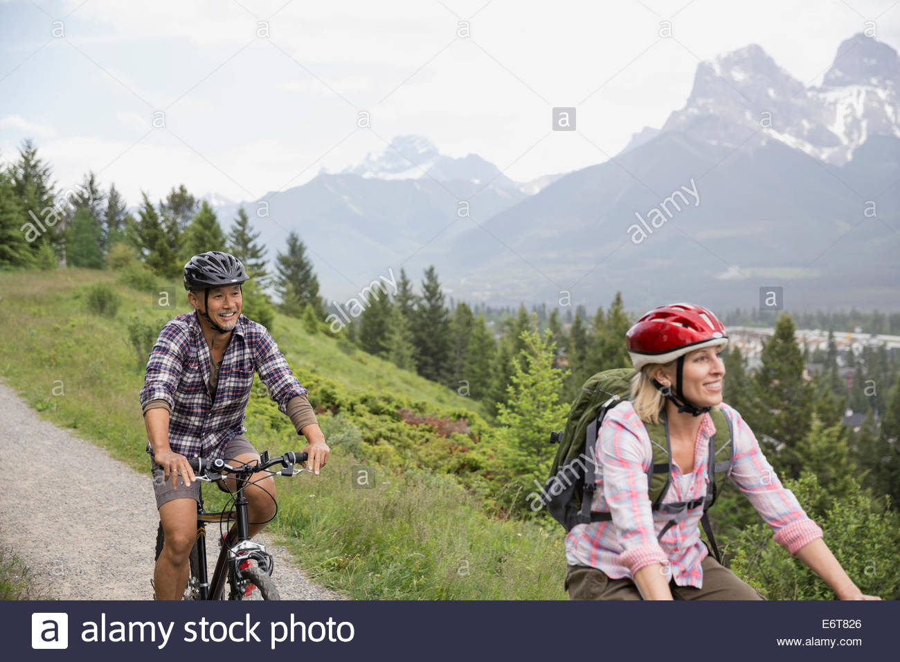 Couple riding mountain bikes on hillside Stock Photo Alamy