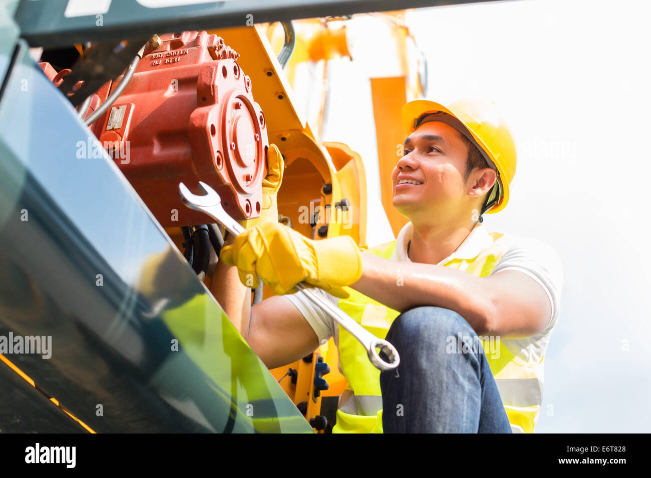 Asian engine mechanic engineer doing maintenance on machine Stock Photo