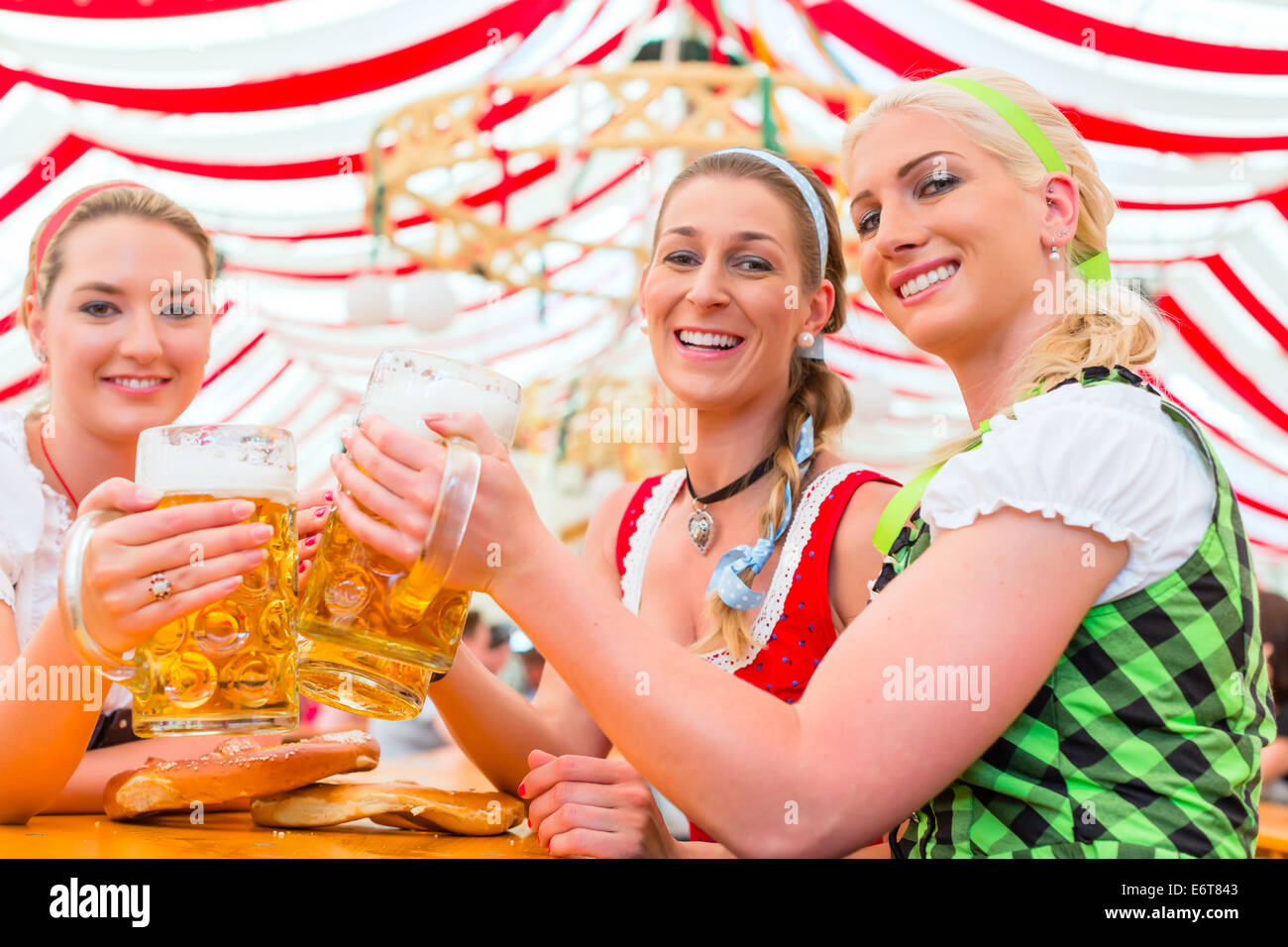 Friends drinking together Bavarian beer in national costume or Dirndl on Oktoberfest Stock Photo