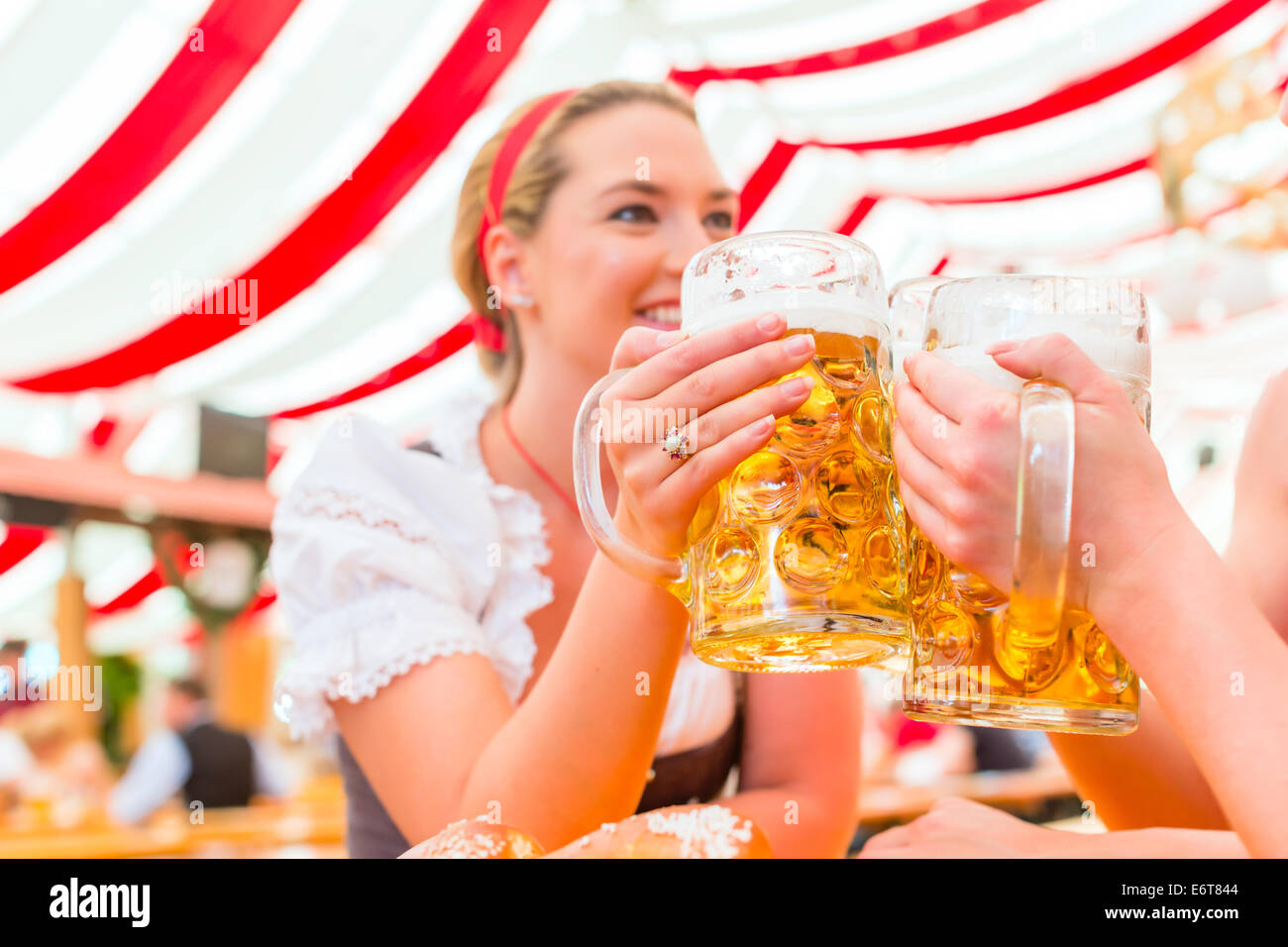 Friends drinking together Bavarian beer in national costume or Dirndl on Oktoberfest Stock Photo