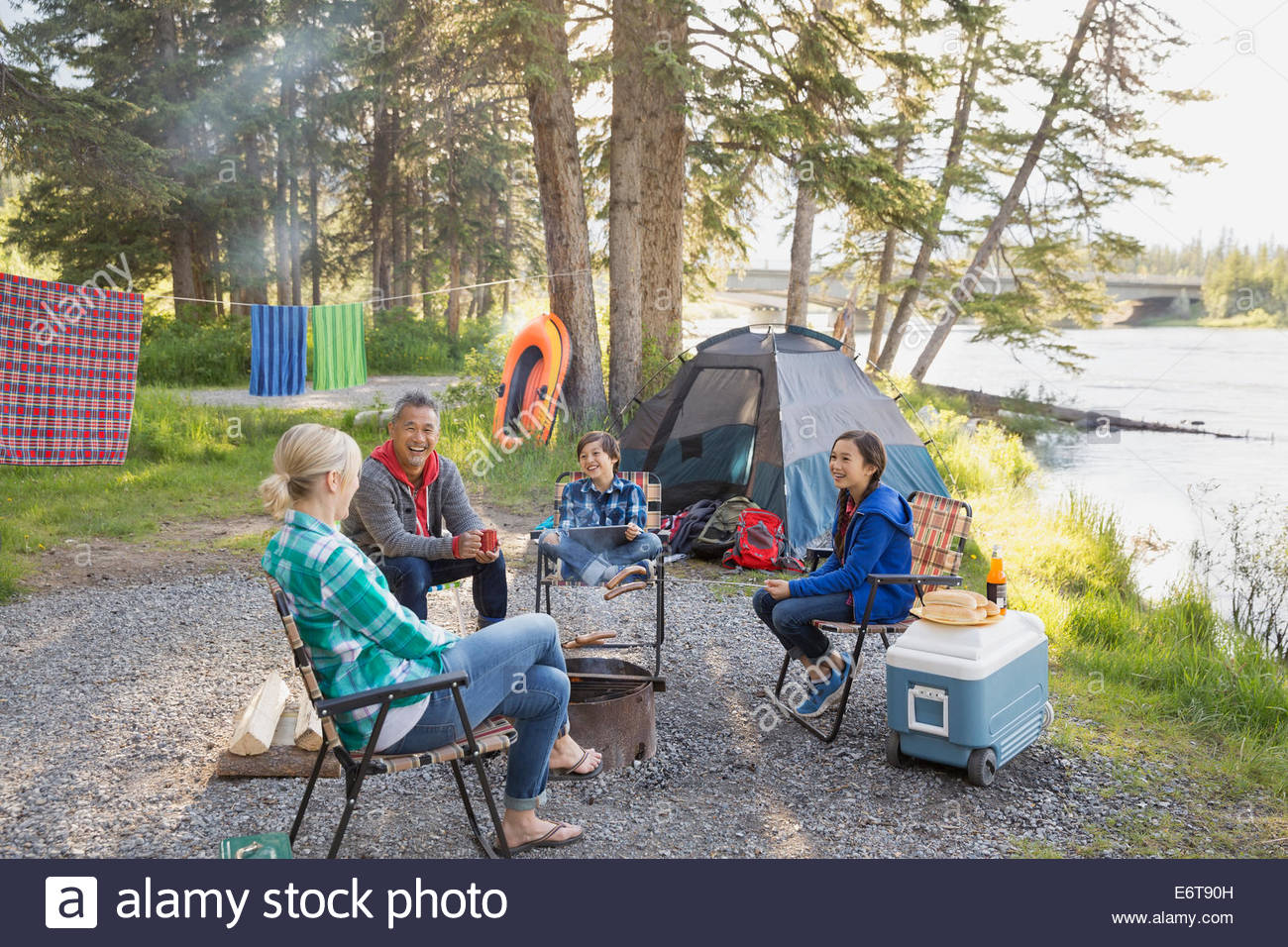 Family relaxing together around campfire Stock Photo