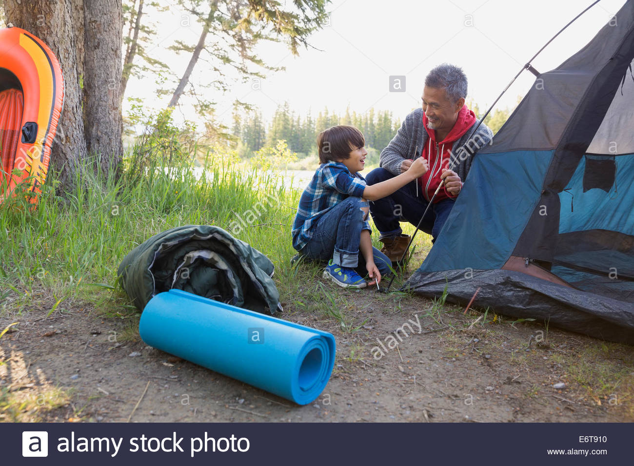 Father and son pitching tent at campsite Stock Photo
