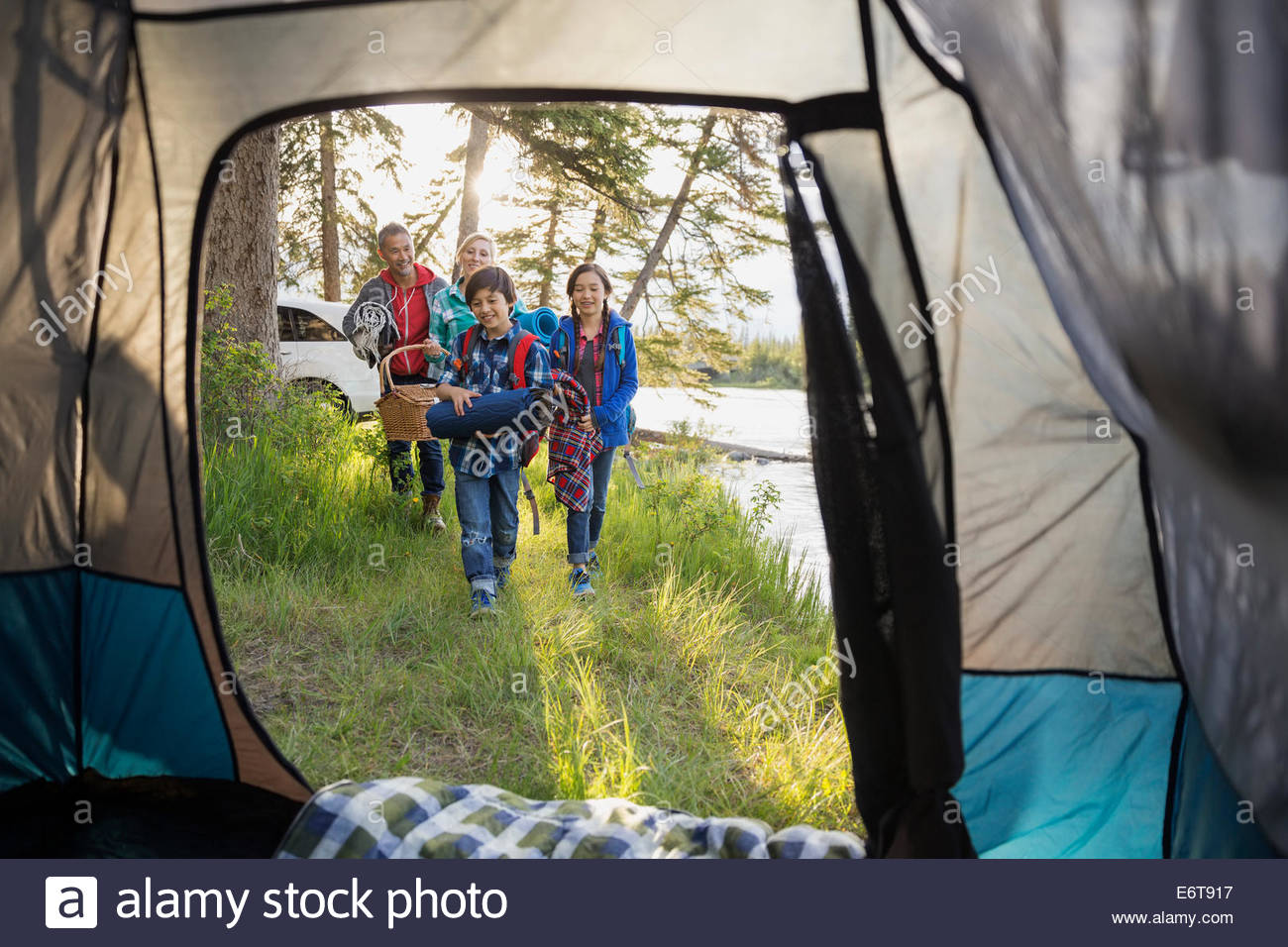 Family carrying gear at campsite Stock Photo