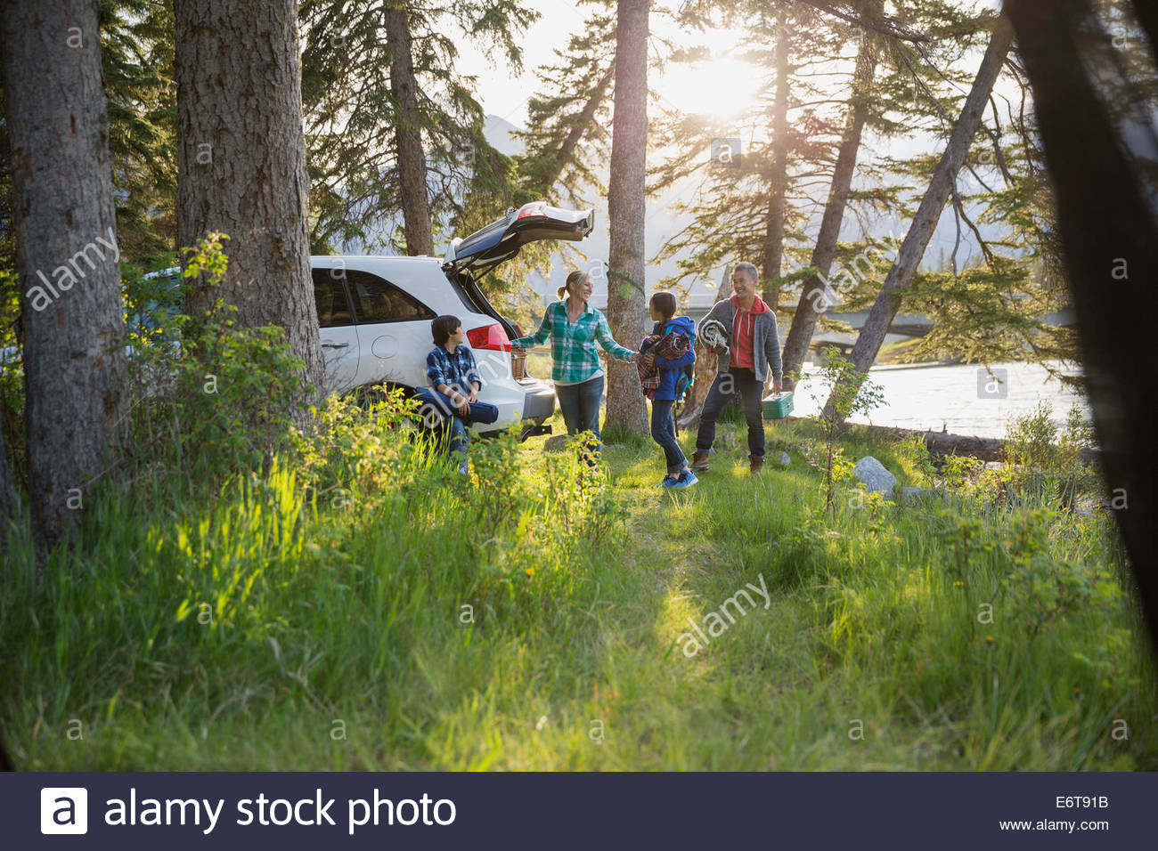 Family unpacking car at campsite Stock Photo