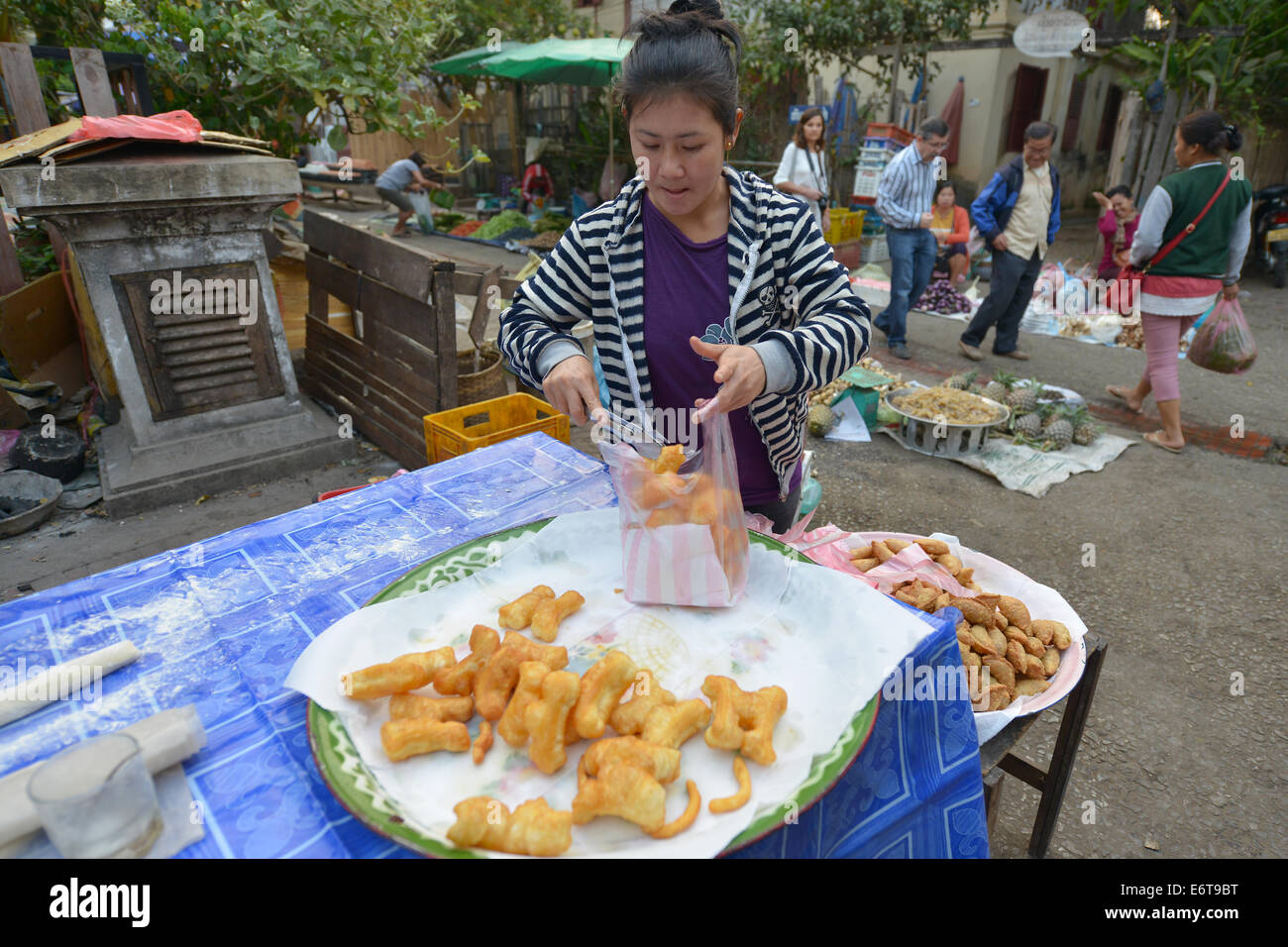 Luang Prabang, Laos - March 1, 2014: Woman sells food at the market in Luang Prabang, Laos. Stock Photo