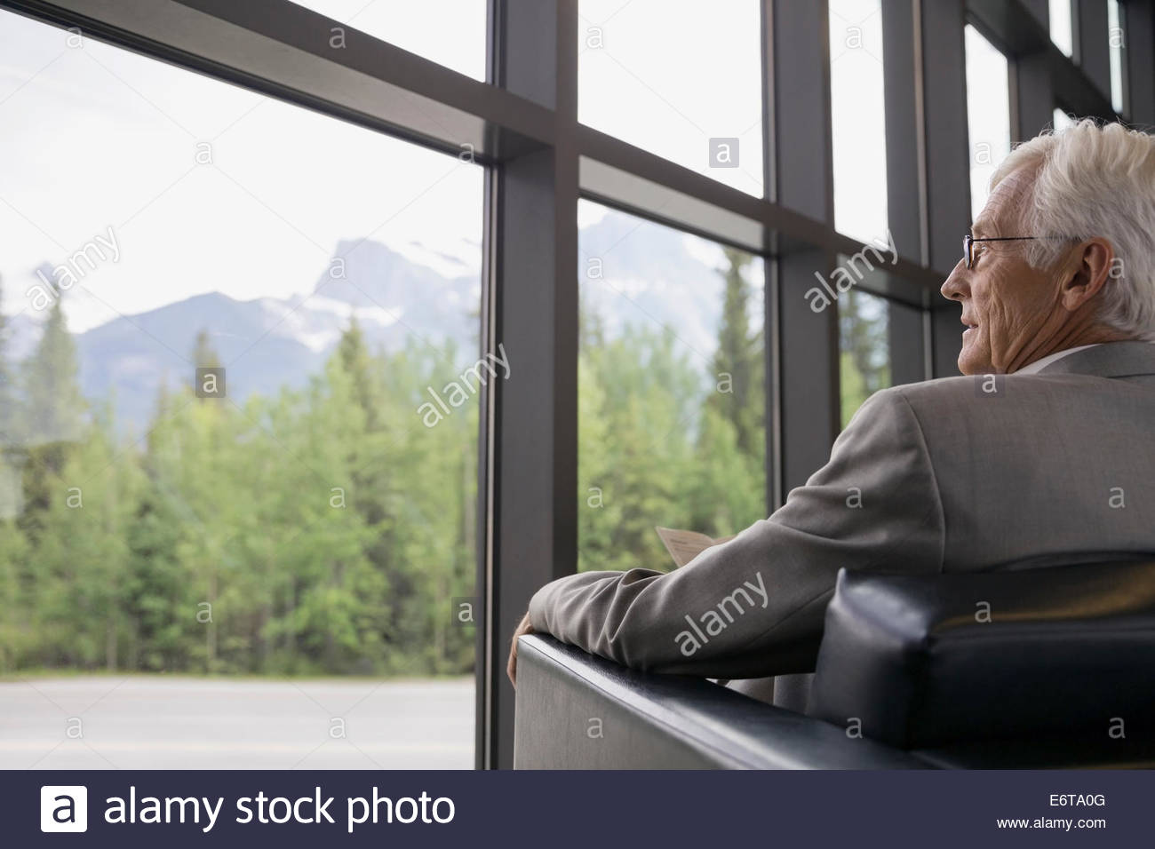 Businessman sitting near lobby window Stock Photo