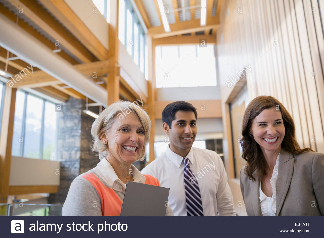 Business people smiling in office lobby Stock Photo - Alamy