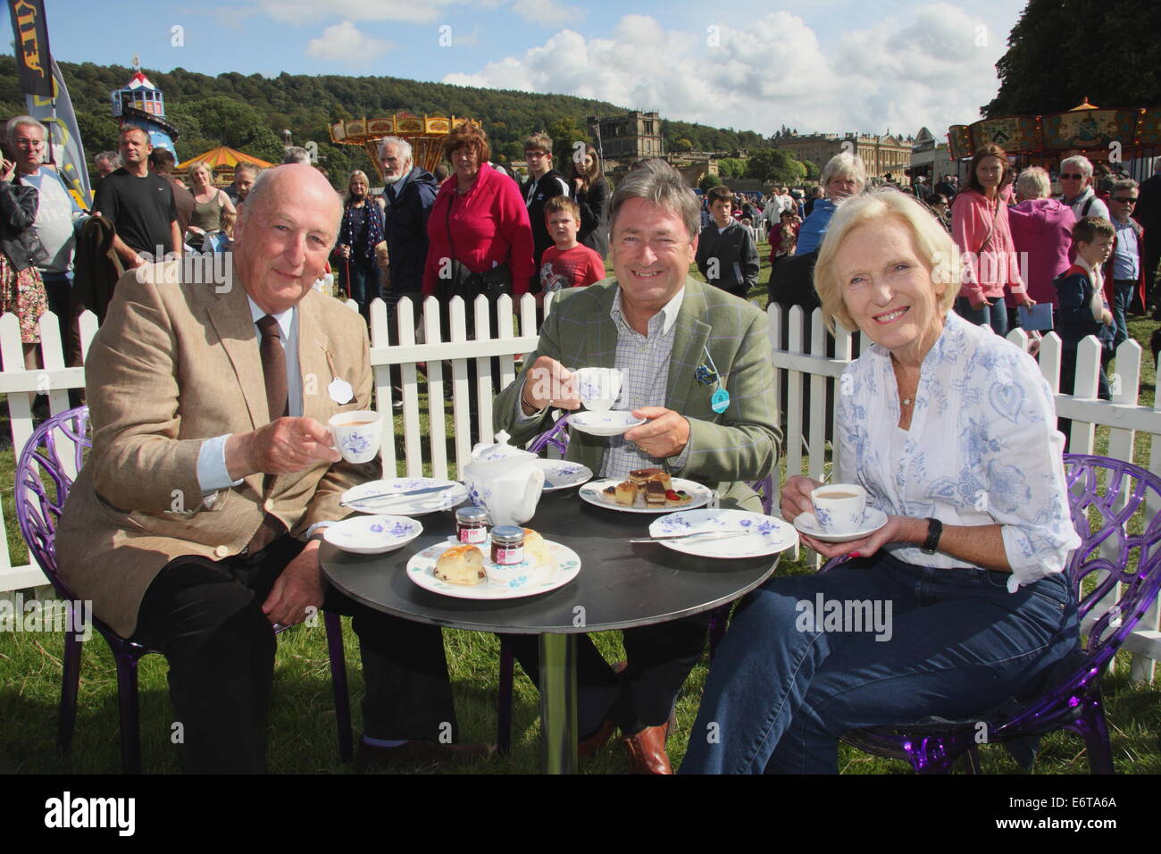 Peak District, Derbyshire, UK. 30 August 2014. Chatsworth House provides the backdrop to afternoon tea for the Duke of Devonshire (L), broadcaster, Alan Titichmarsh (C) and Great British Bake Off television show judge, cook and author, Mary Berry. Hosted by the Duke and Duchess of Devonshire, Chatsworth Country Fair is held in the parkland surrounding Derbyshire stately home, Chatsworth House. The event runs until 31 August. Credit:  Matthew Taylor/Alamy Live News Stock Photo