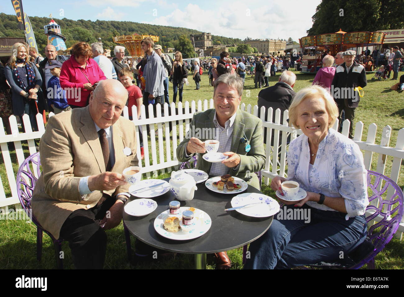 Peak District, Derbyshire, UK. 30 August 2014. Chatsworth House provides the backdrop to afternoon tea for the Duke of Devonshire (L), broadcaster, Alan Titichmarsh (C) and Great British Bake Off television show judge, cook and author, Mary Berry. Hosted by the Duke and Duchess of Devonshire, Chatsworth Country Fair is held in the parkland surrounding Derbyshire stately home, Chatsworth House. The event runs until 31 August. Credit:  Matthew Taylor/Alamy Live News Stock Photo