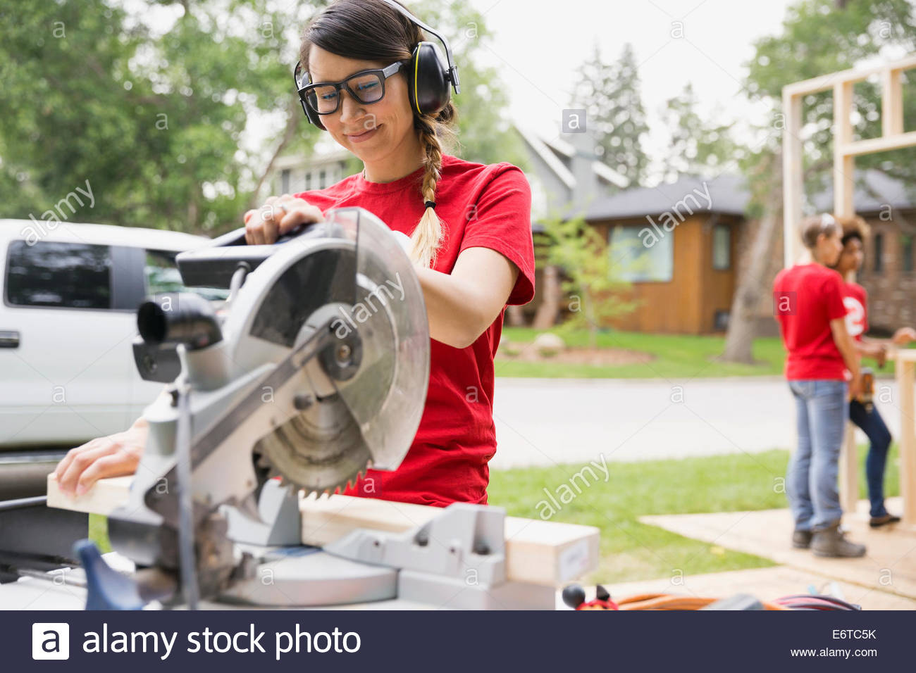 Volunteer using table saw near construction frame Stock Photo