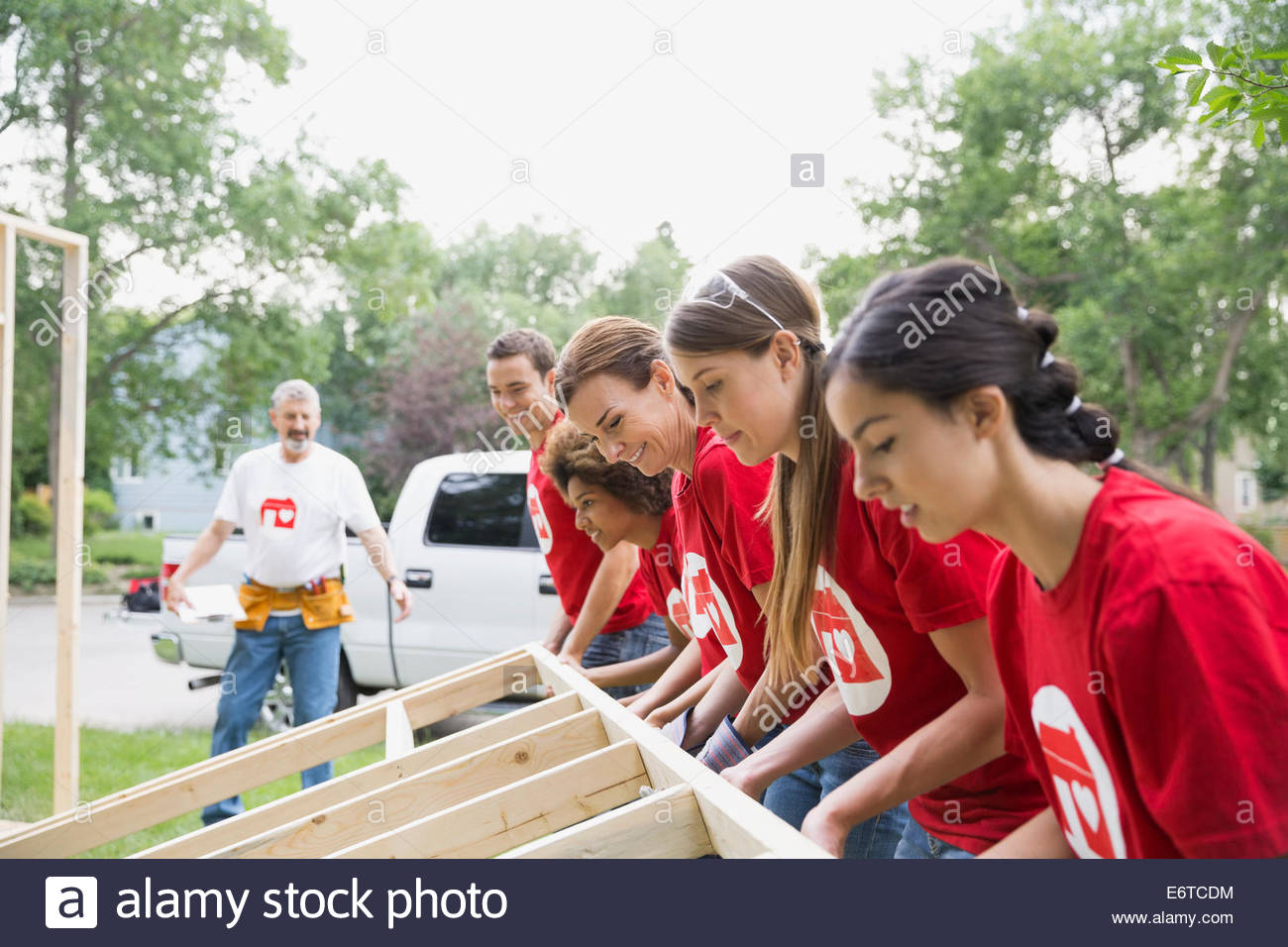 Volunteers lifting construction frame Stock Photo