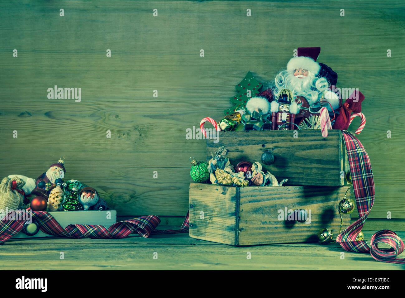 Old christmas decoration with santa on wooden background in green and red. Stock Photo