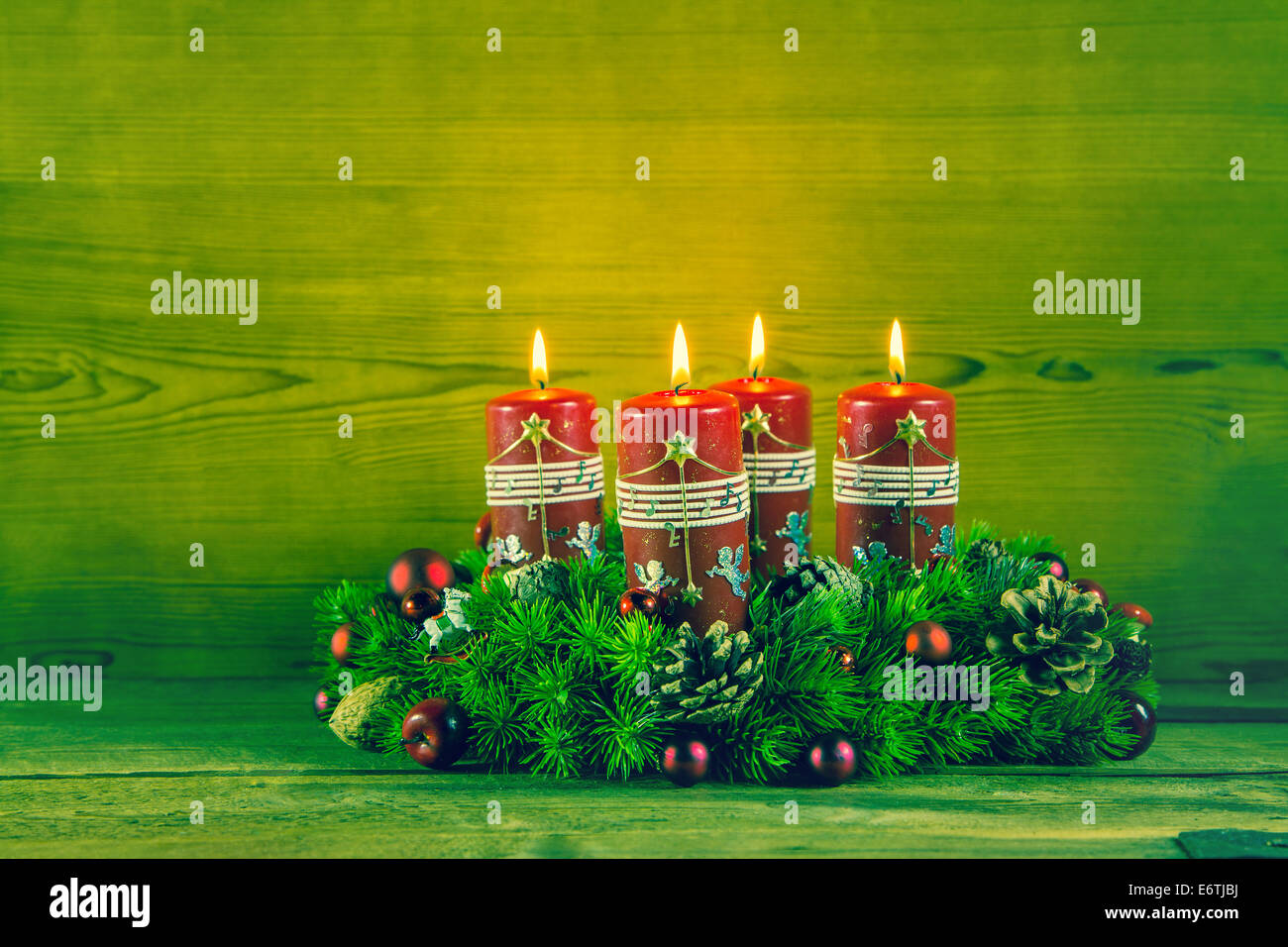 Traditional advent wreath or crown with four red burning candles on wooden background. Stock Photo
