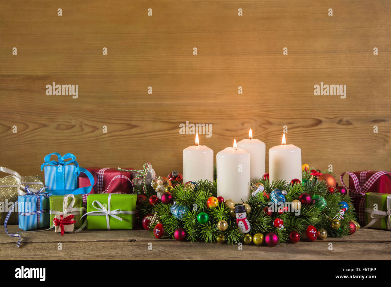 Christmas presents and advent wreath on wooden colorful background for decoration. Stock Photo