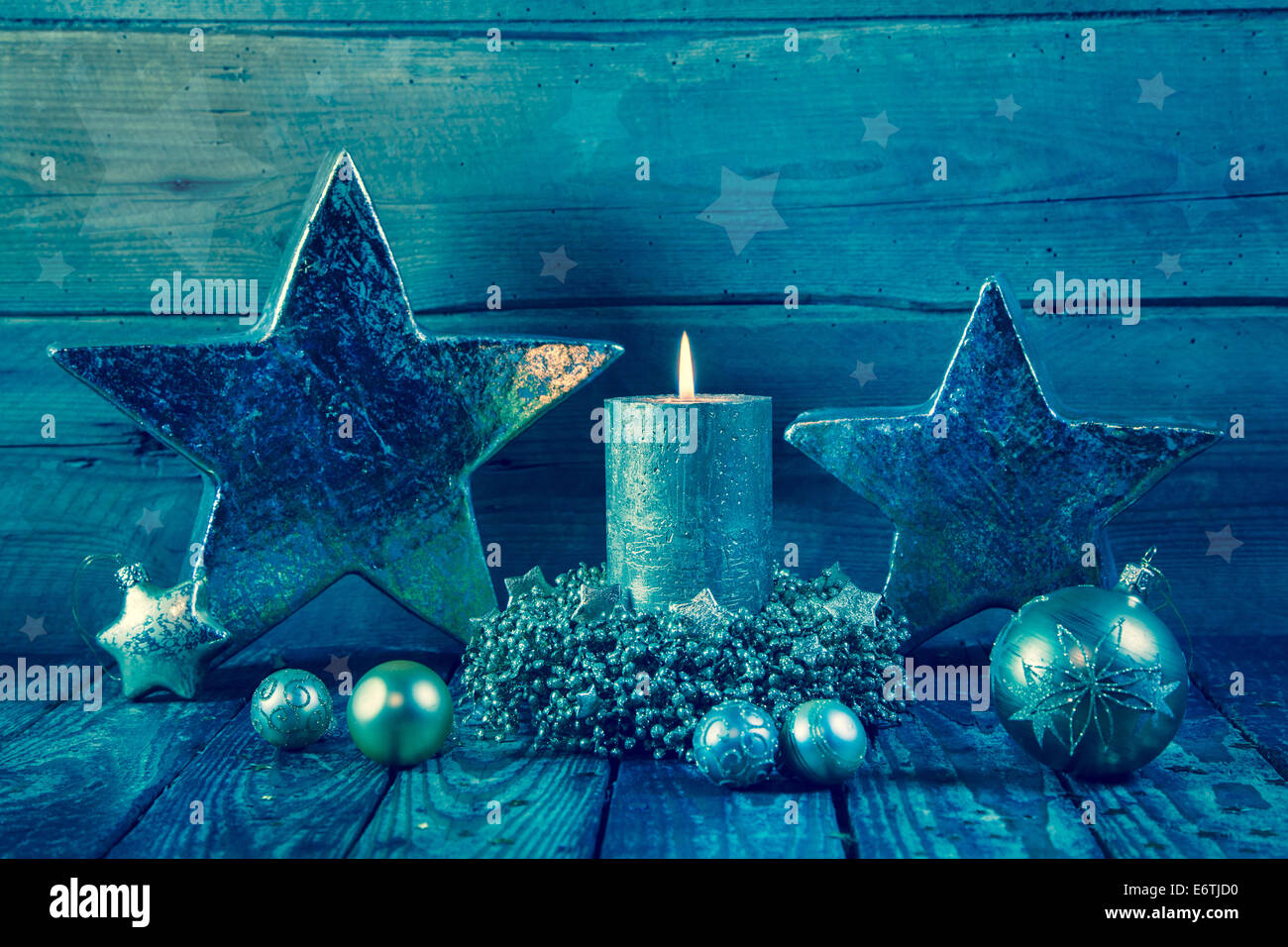 First advent: one burning golden candle on a wooden blue background. Stock Photo