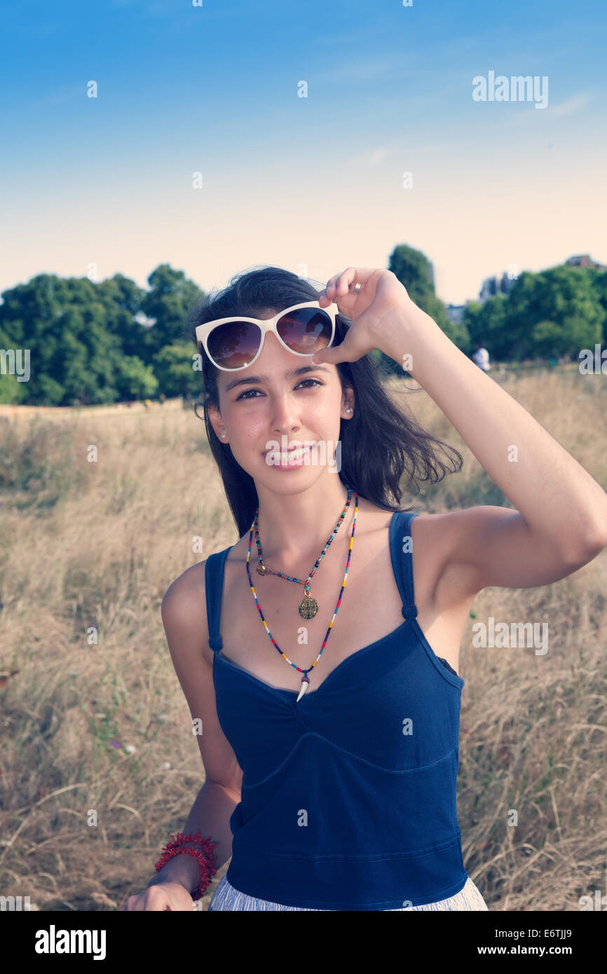 A young woman with brown hair in her Twenties relaxing in Hyde Park / Kensington Gardens in London in the summer Stock Photo