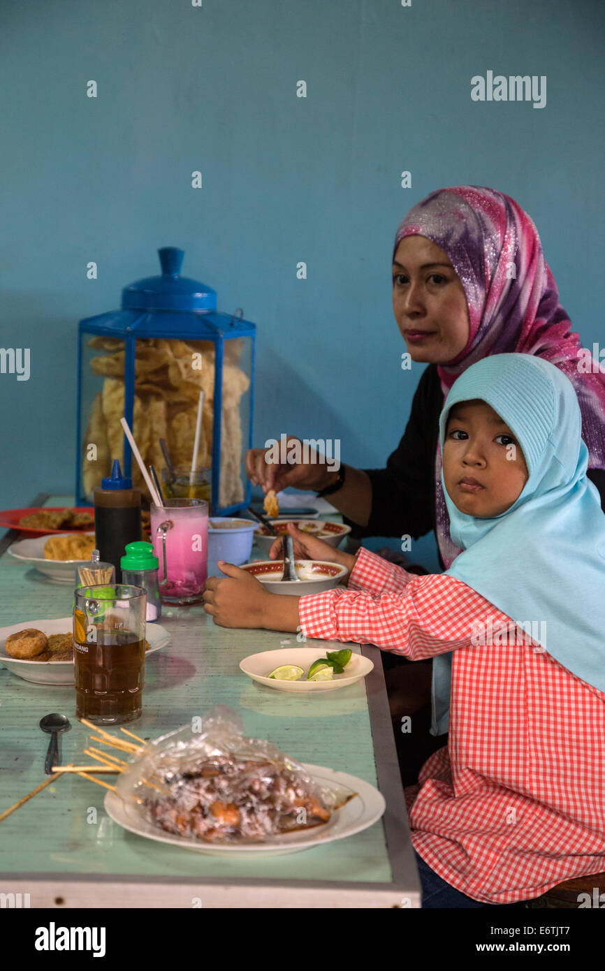 Yogyakarta, Java, Indonesia.  Mother and Daughter Having Lunch, Beringharjo Market. Stock Photo