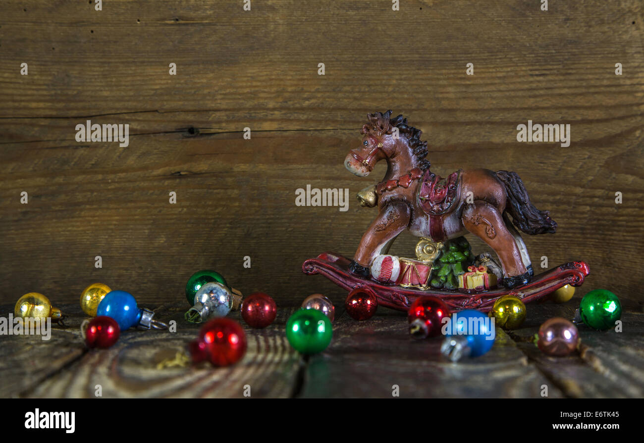 Colorful christmas background with a rocking horse and old balls. Stock Photo