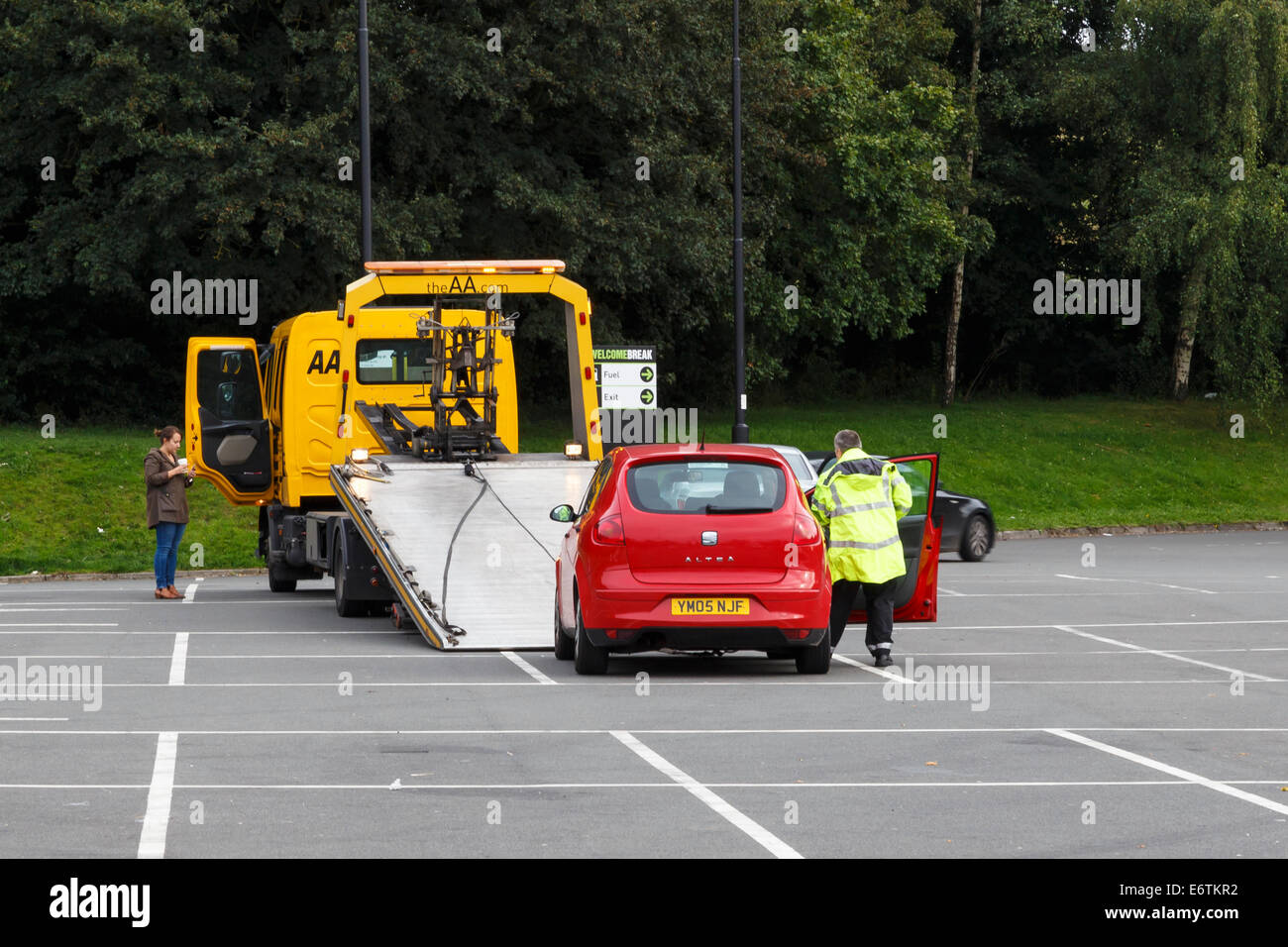 Lone young female motorist having broken down car recovered by the AA. Stock Photo