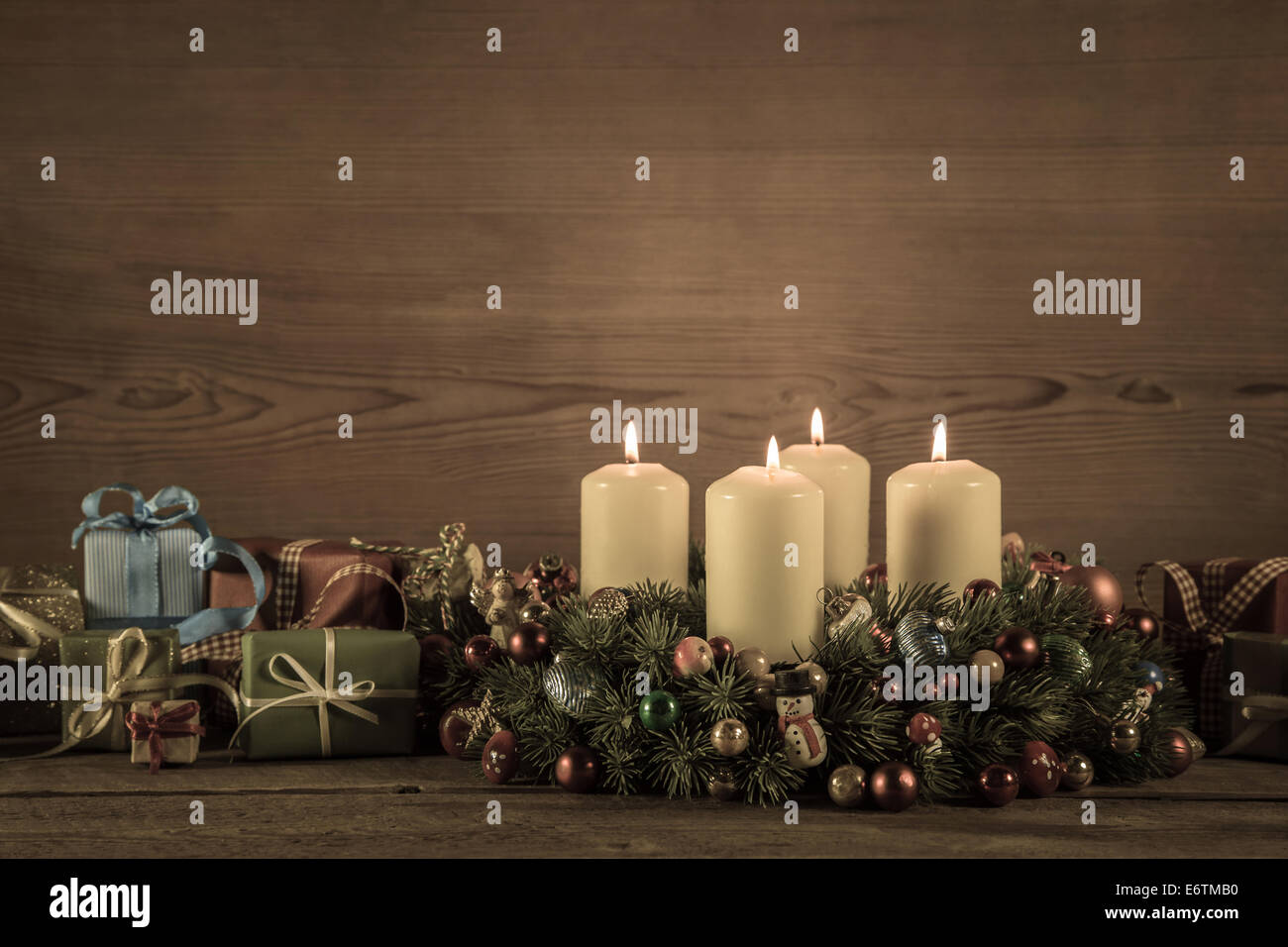 Advent wreath or crown with four burning candles and christmas gifts for a voucher. Stock Photo
