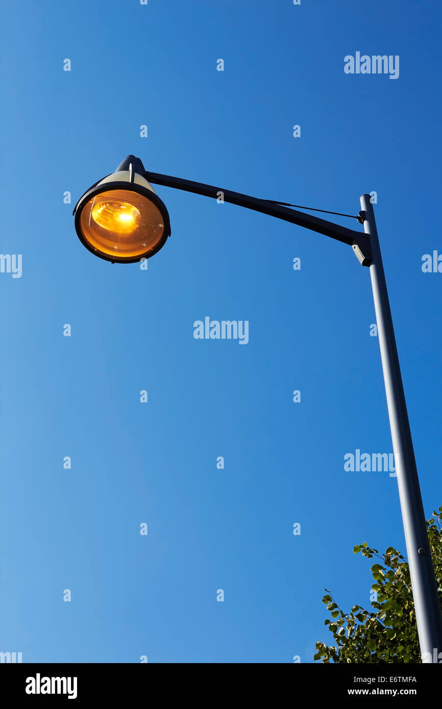 orange streetlamp against blue sky Stock Photo