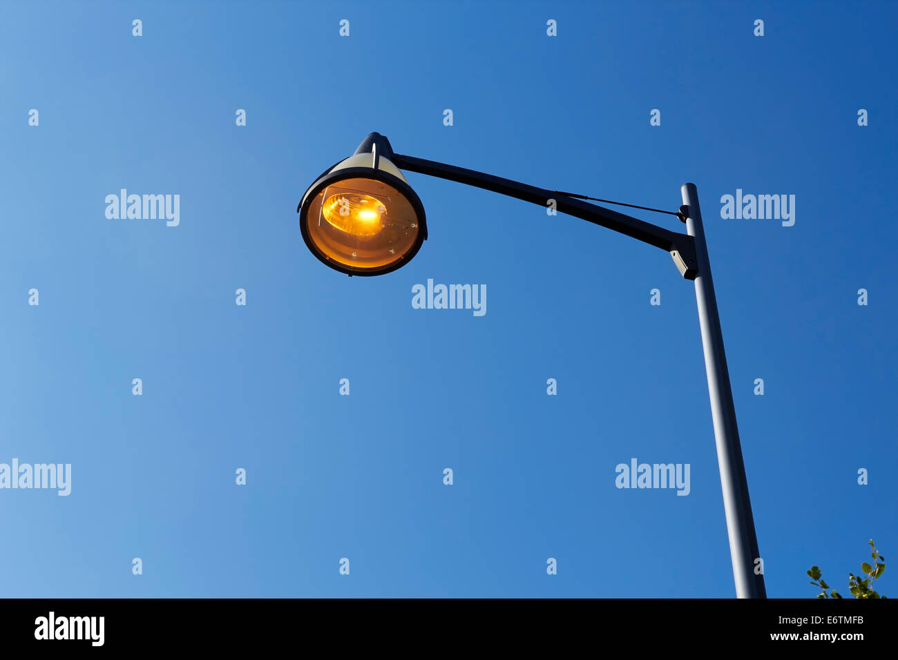 orange streetlamp against blue sky Stock Photo