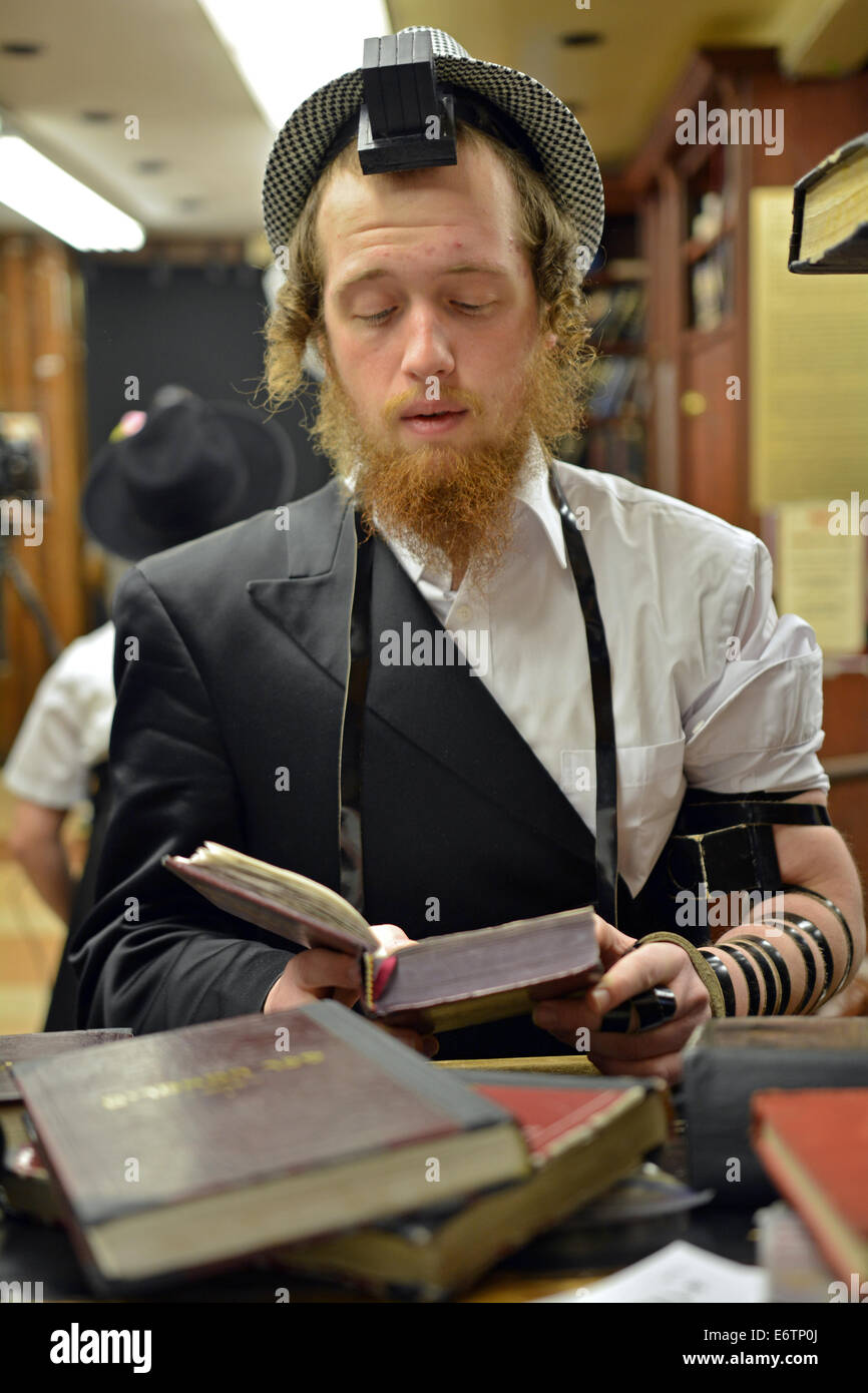 A young Jewish man in a hat at morning services on Purim in Crown Heights, Brooklyn, New York Stock Photo