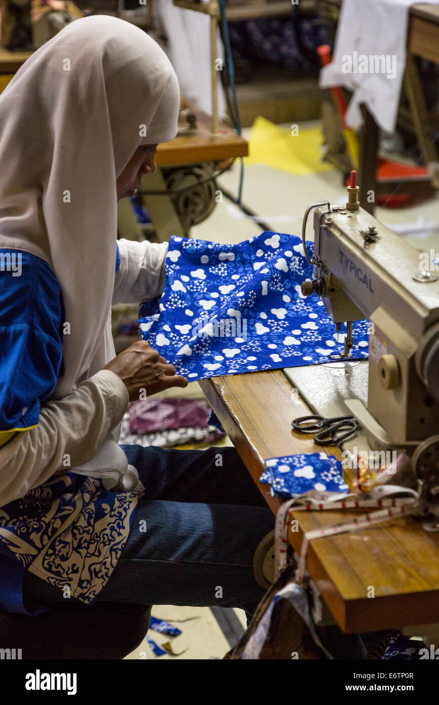 Yogyakarta, Java, Indonesia.  Batik Workshop.  Woman Sewing Batik Cloth. Stock Photo
