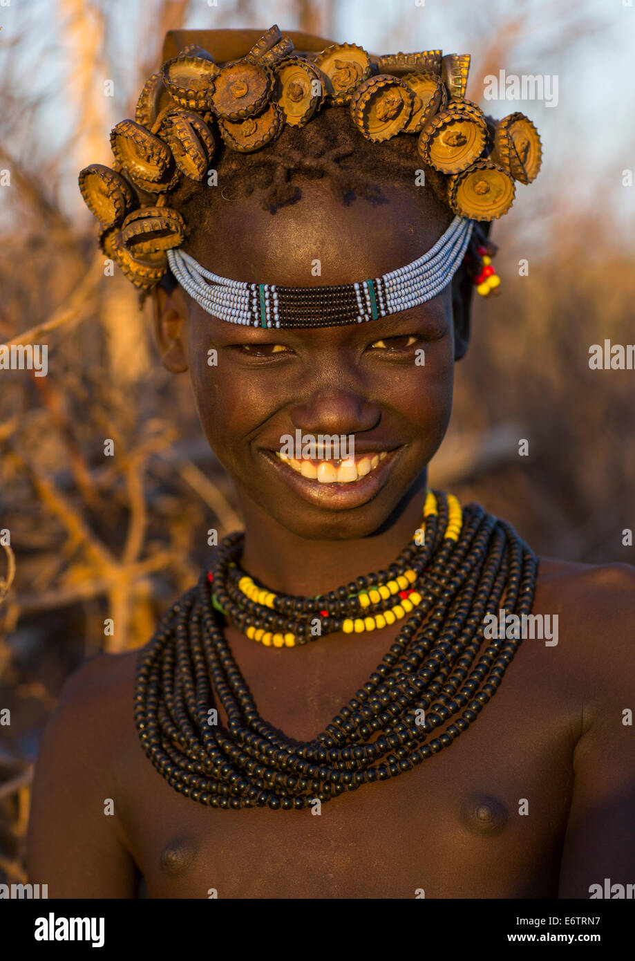 Portrait Of A Young Dassanech Girl Wearing Bottle Caps Headgear And Beaded Necklaces, Omorate, Omo Valley, Ethiopia Stock Photo