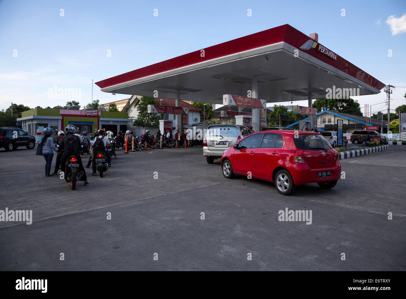 Yogyakarta, Java, Indonesia.  Motorbikes and Cars Lining Up for Fuel at Local Gas Station. Stock Photo