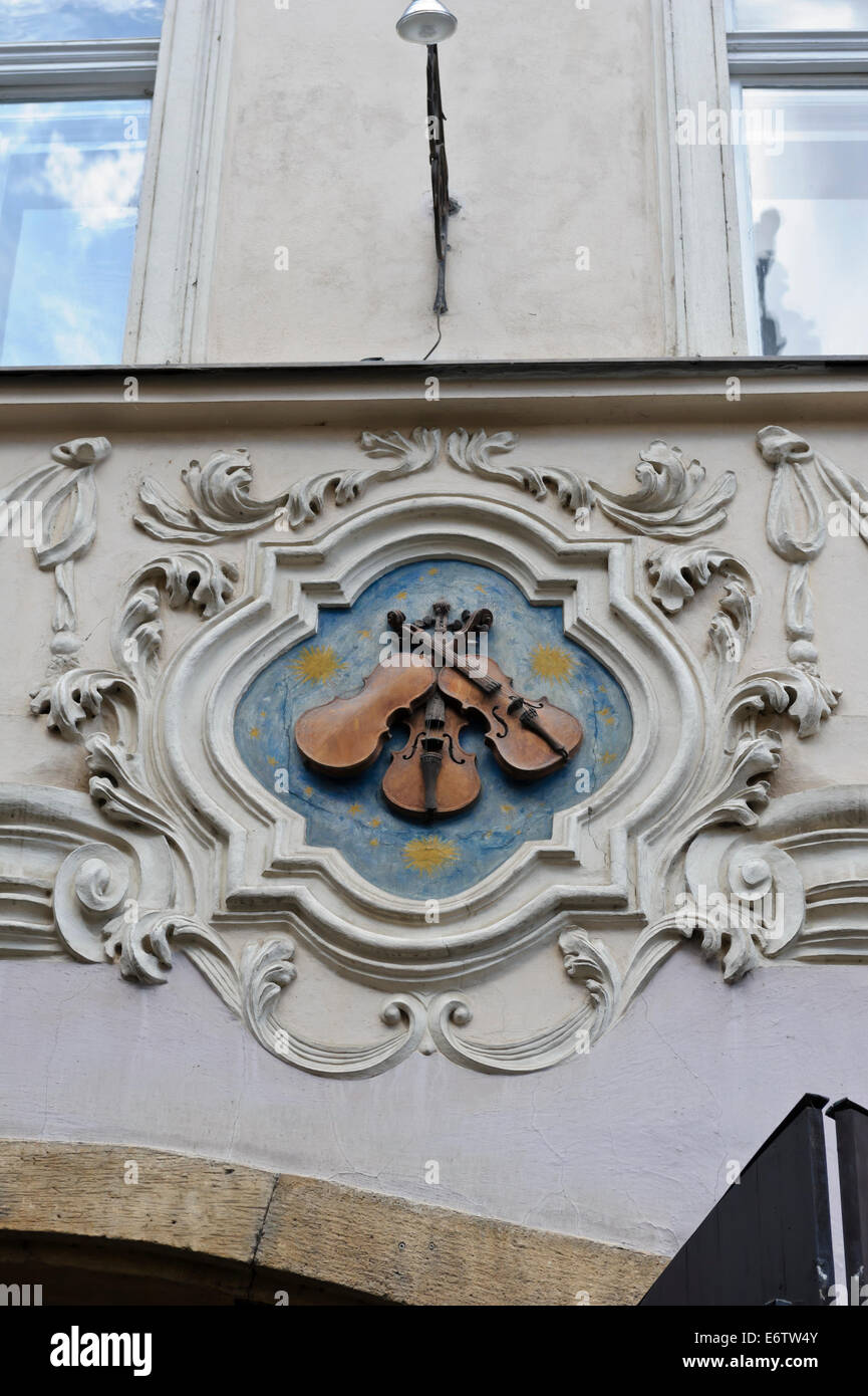 The historic house sign of the 'Three Fiddles' on the wall of a building in City of Prague, Czech Republic. Stock Photo