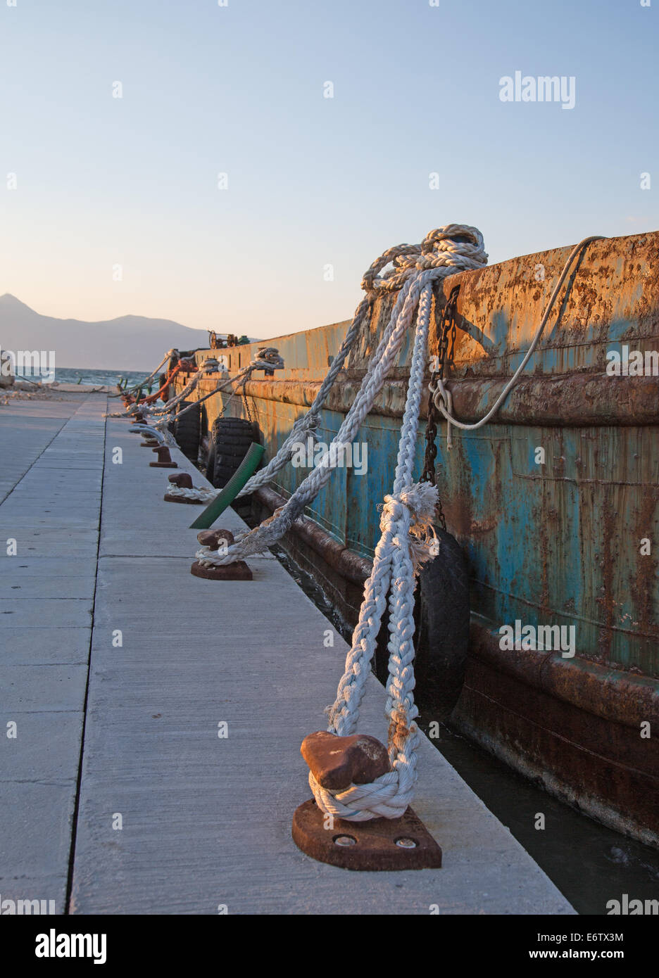 Old sisal ropes on a old rustic and rusty cargo boat in the port. Stock Photo