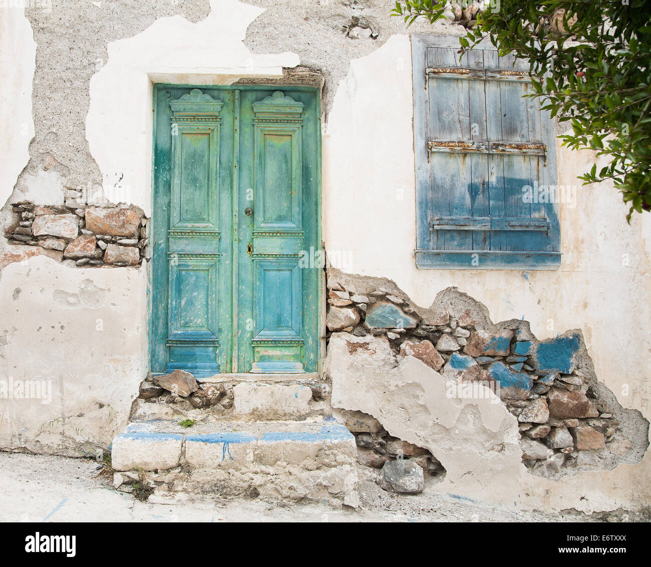 Old wooden door of a shabby demaged house facade or front in blue, green and turquoise. Stock Photo