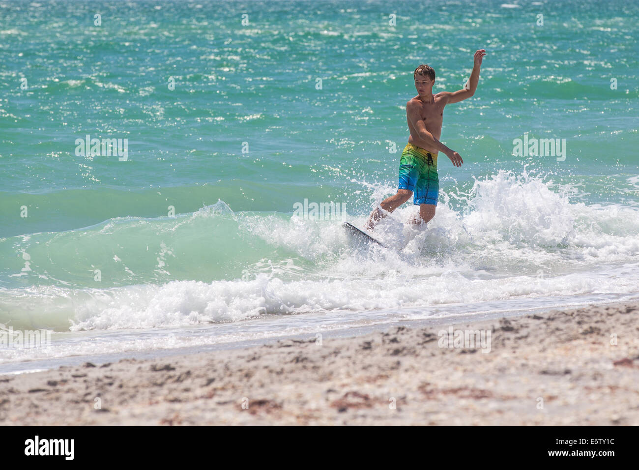 Male Teenager Skimboarding the shoreline in Florida Stock Photo