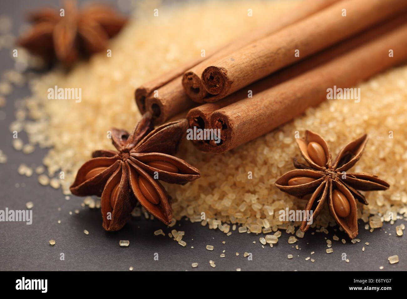 Spices. Cinnamon sticks, star anise and brown sugar. Black background. Closeup. Stock Photo
