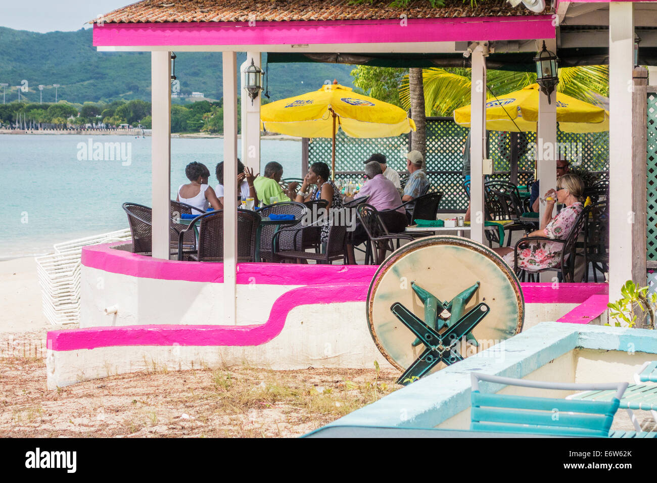 Diners eat and drink on the patio of a beachside restaurant on