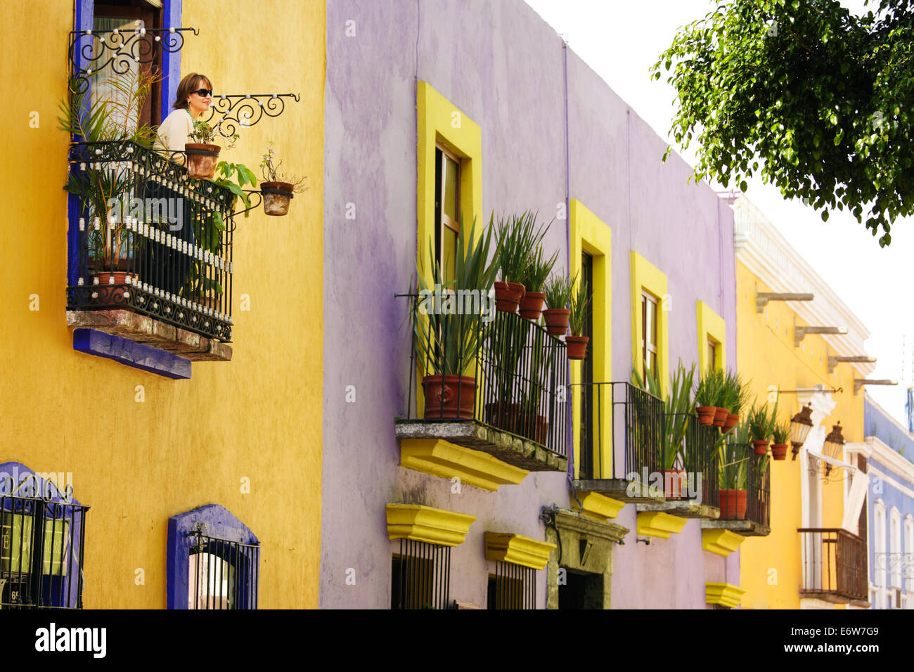 A tourist looks out at Callejon de los Sapos, a colorful street in Puebla, Mexico. Stock Photo