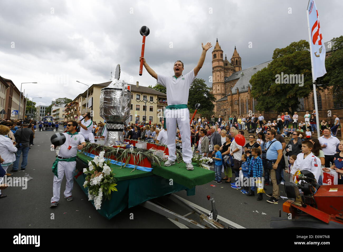 Worms, Germany. 31st Aug, 2014. The winners of the Fischerstechen (fishermen's joust) in Worms 2013 are pictured on a float with a giant replica cup. The cathedral of Worms can be seen in the background. The first highlight of this year's Backfischfest was the big parade through the city of Worms with 125 groups and floats. Community groups, sport clubs, music groups and business from Worms and further afield took part. © Michael Debets/Pacific Press/Alamy Live News Stock Photo