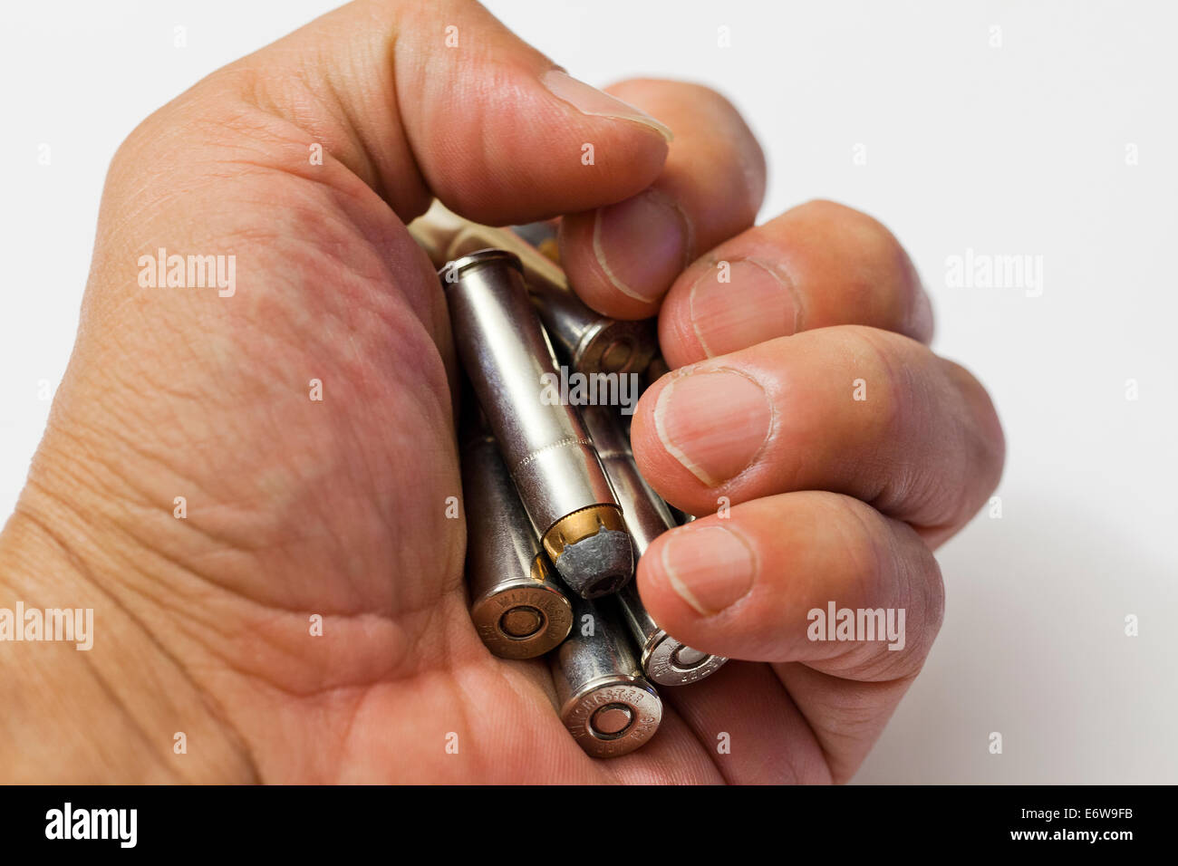 Man gripping (clutching) handful of bullets - USA Stock Photo
