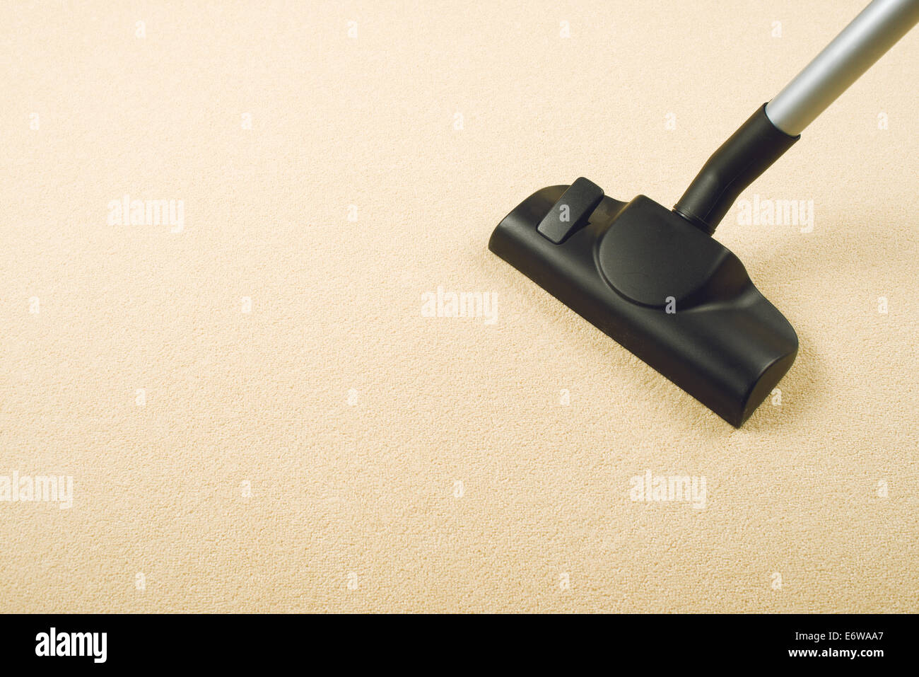 Vacuum Cleaner sweeping Brand New Carpet. Housework and home hygiene. Stock Photo