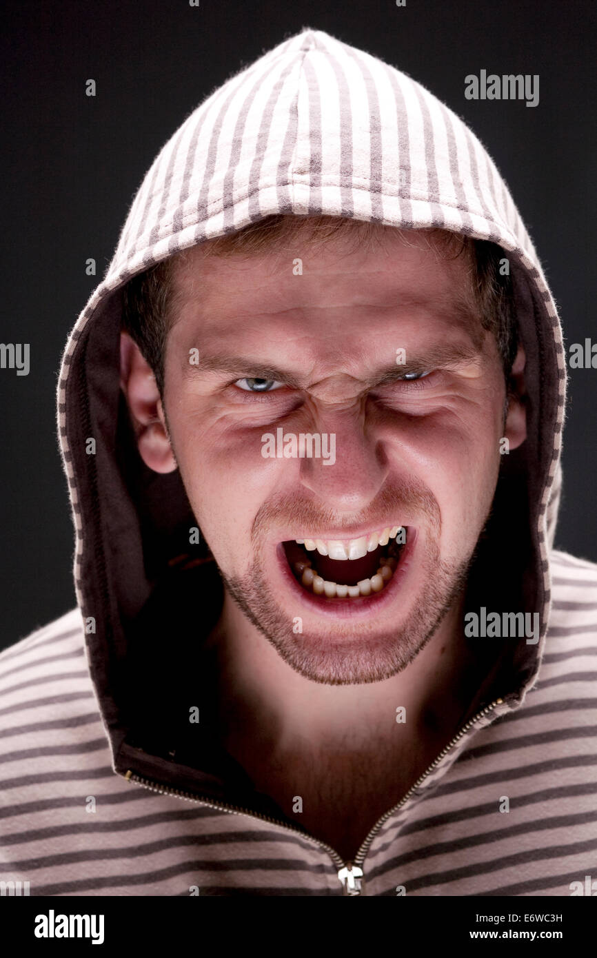 Portrait of young angry screaming man with a hood. Stock Photo