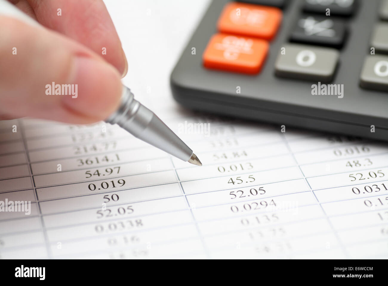 Analyzing financial statements. Focus on ballpoint pen. Shallow depth of field. Close-up. Stock Photo