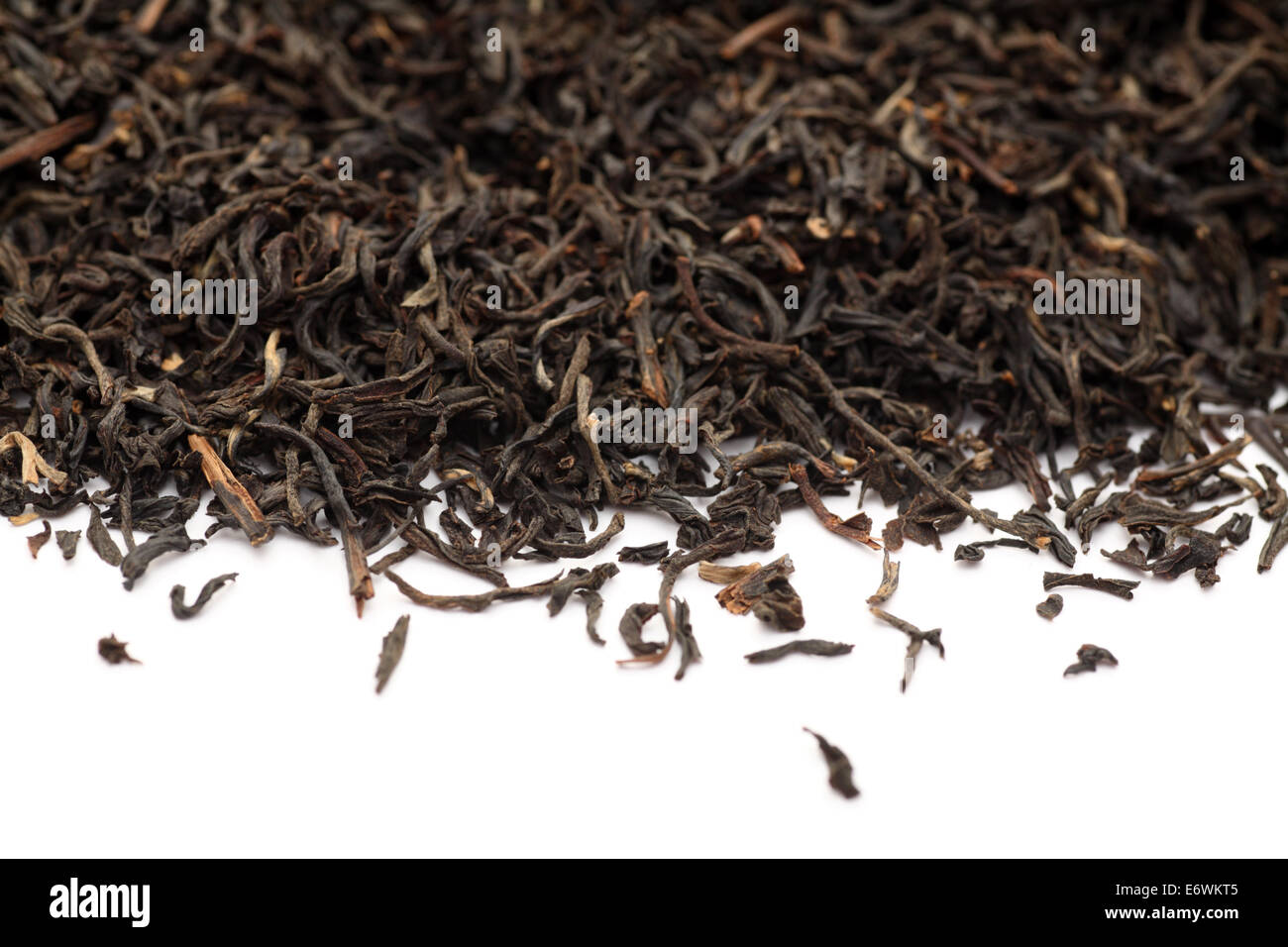 Black tea leaves on white background. Closeup. Stock Photo