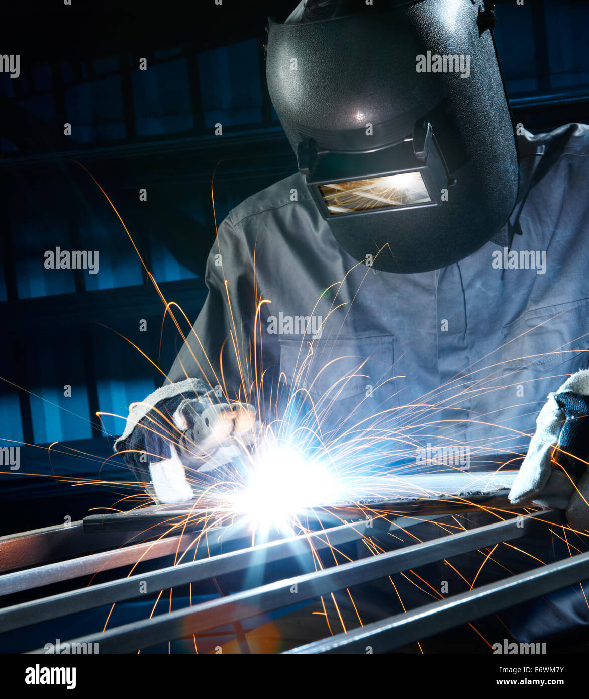 man welding with reflection of sparks on visor Stock Photo